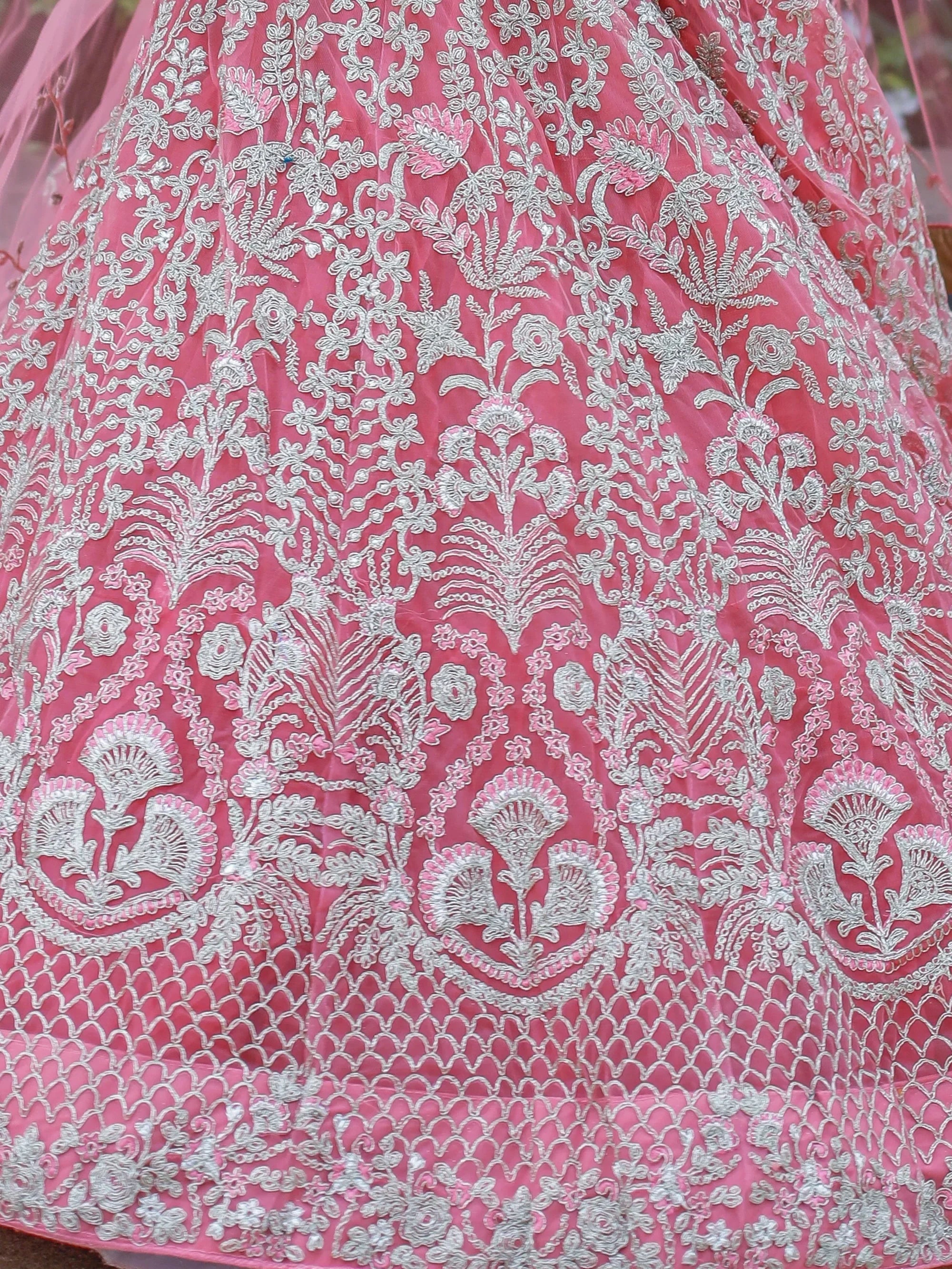 Pink lehenga with silver floral embroidery and net detailing, ideal for Indian ethnic wear occasions.