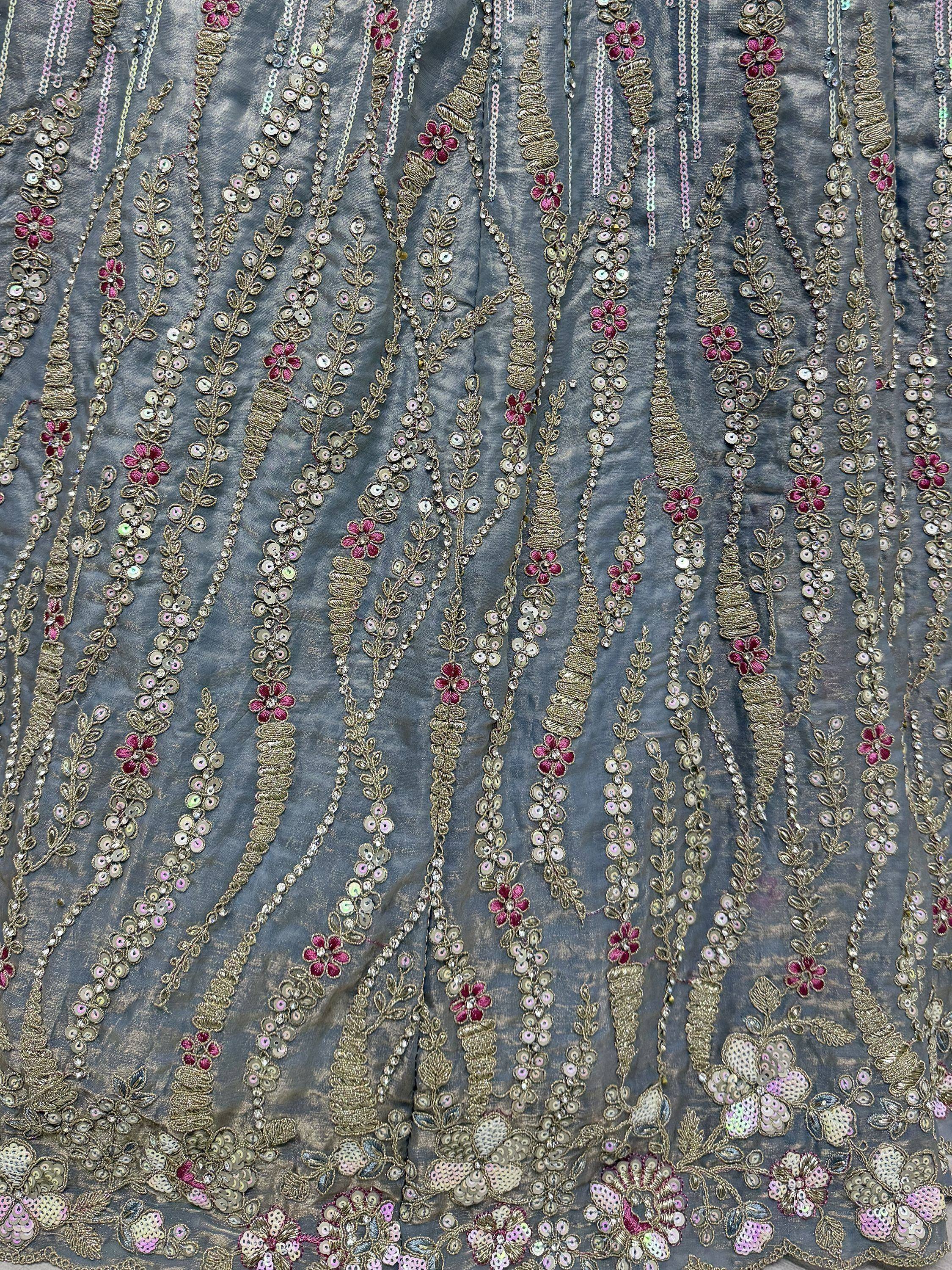 Grey ethnic wear fabric with gold embroidery, pink flowers, and sequin detailing for lehenga or saree