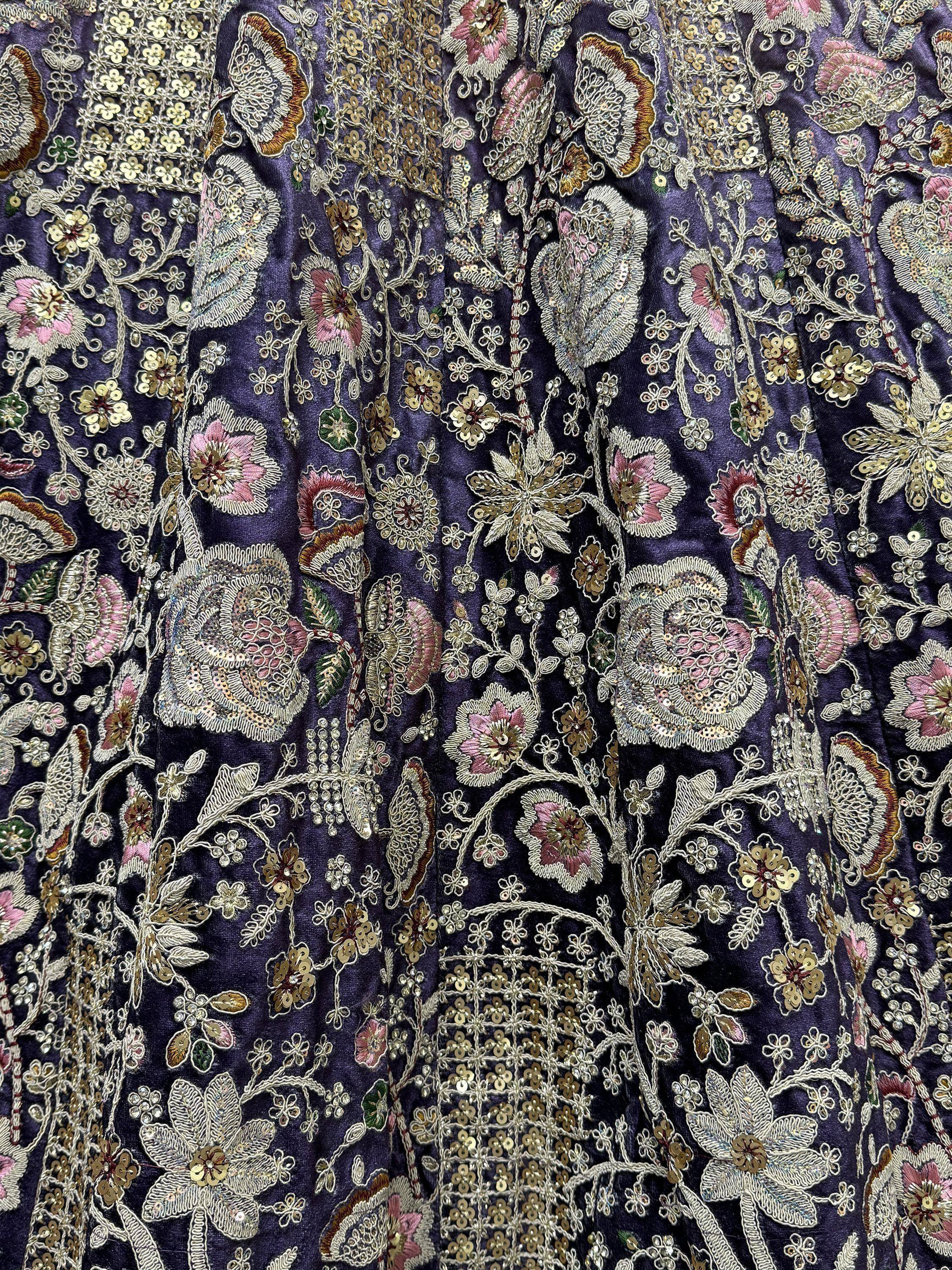 Purple ethnic gown with intricate floral embroidery and sequin detailing for festive occasions