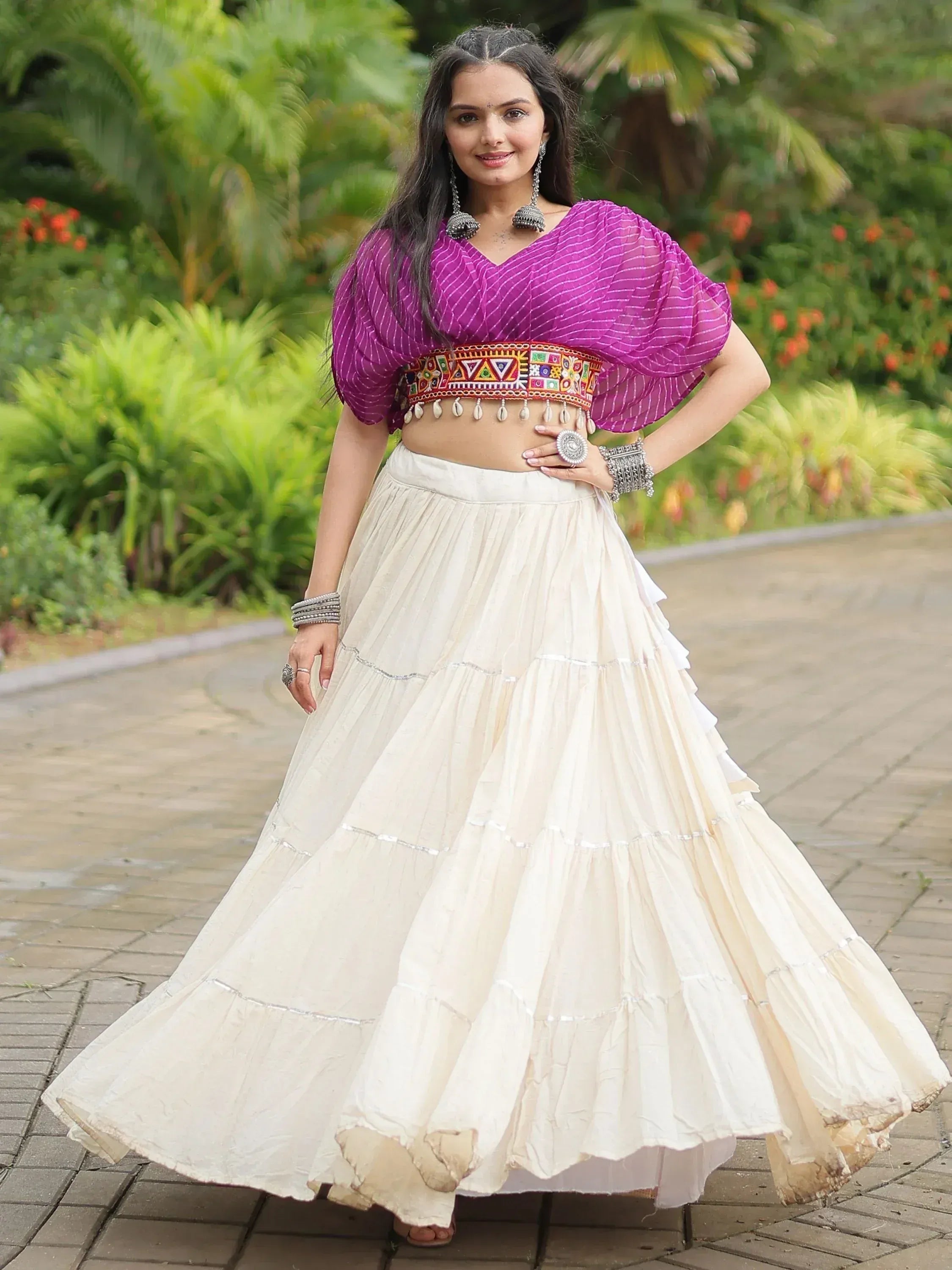 Woman in purple crop top with embroidered belt and cream tiered skirt, Indian ethnic wear