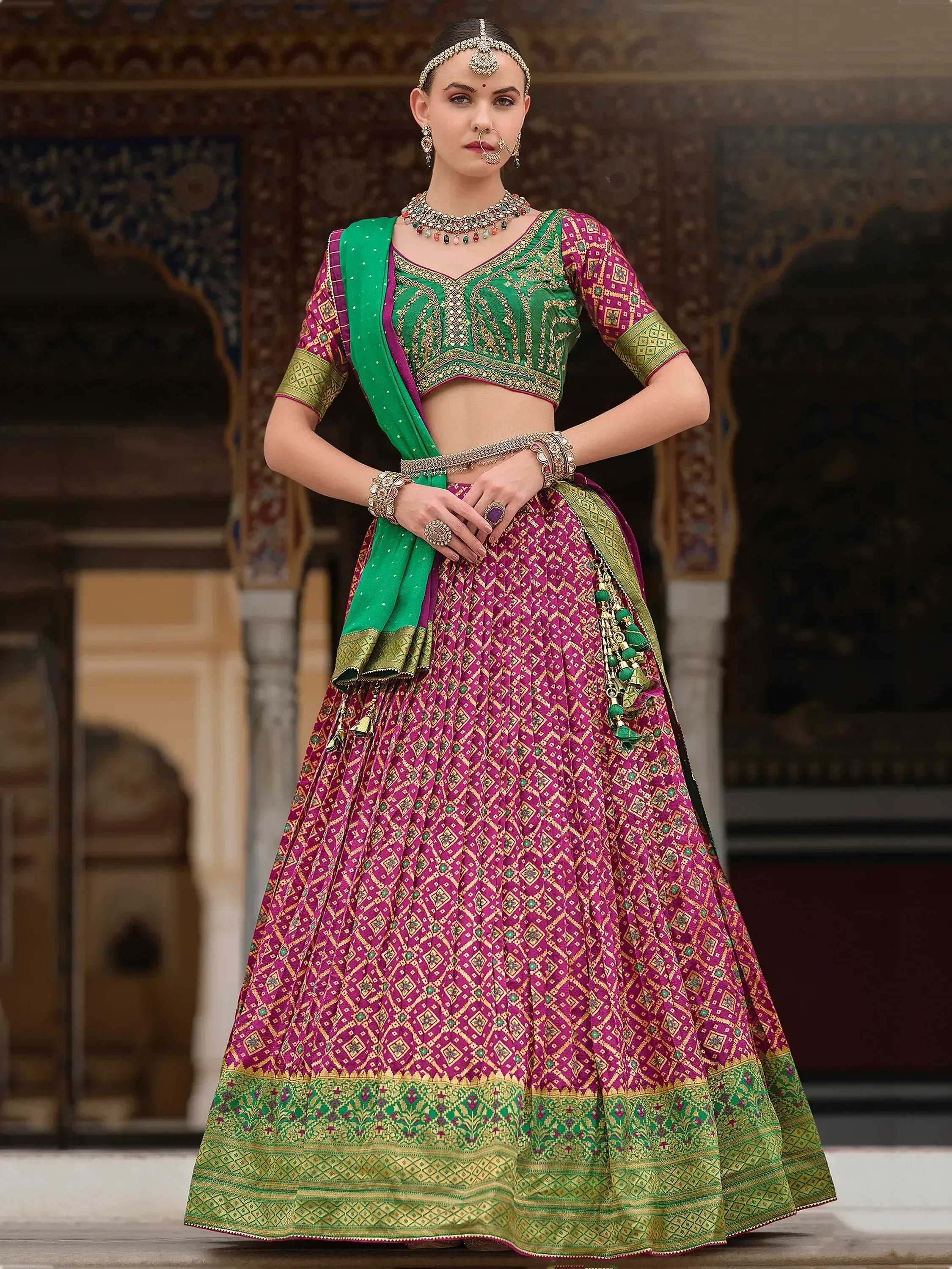 Elegant magenta and green designer lehenga choli with intricate embroidery, perfect for Indian ethnic wear.