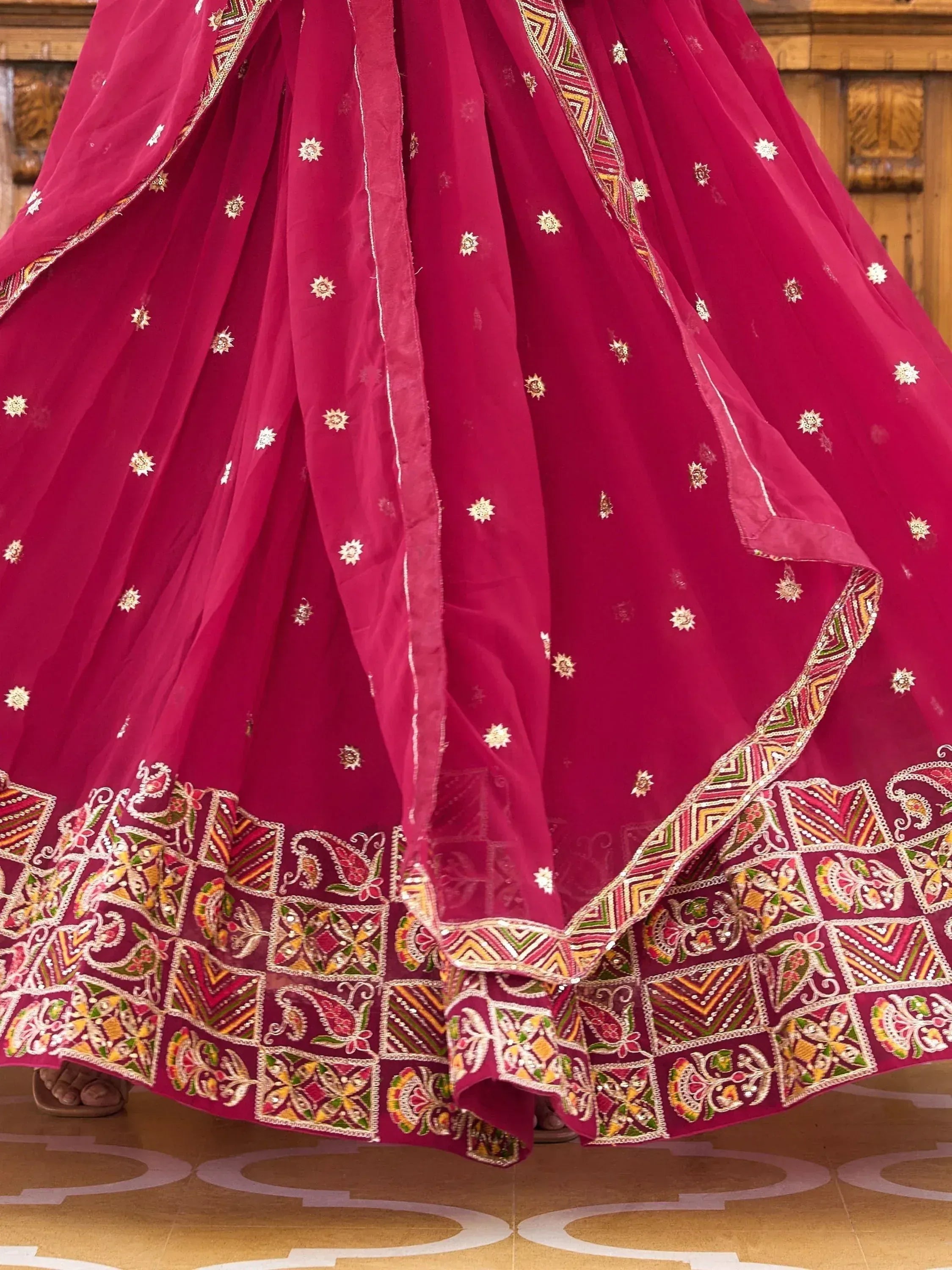 Fuchsia lehenga choli with intricate embroidery and mirror work, perfect for Indian ethnic wear