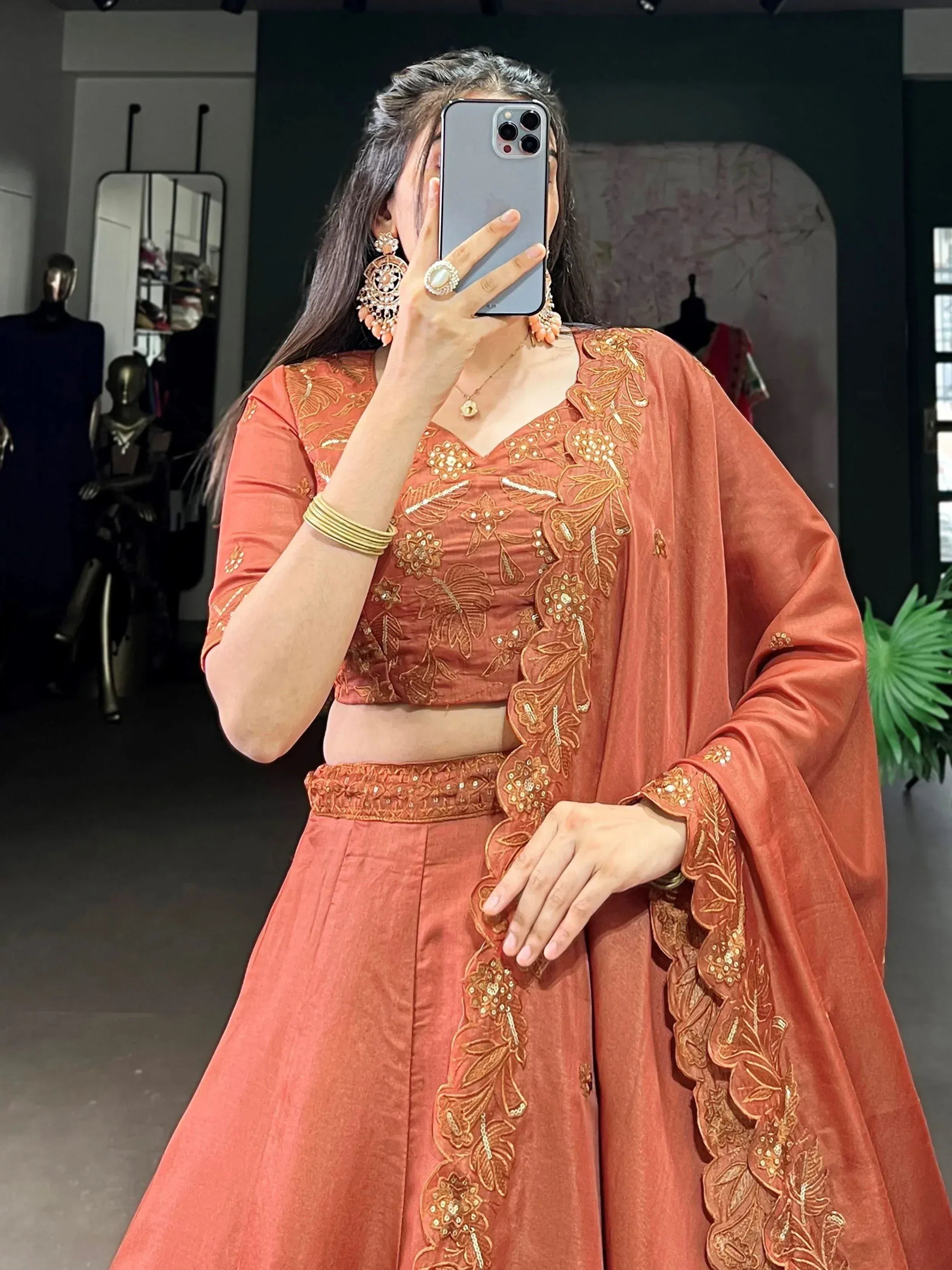 Terracotta lehenga choli with gold floral embroidery, perfect for Indian ethnic wear occasions.