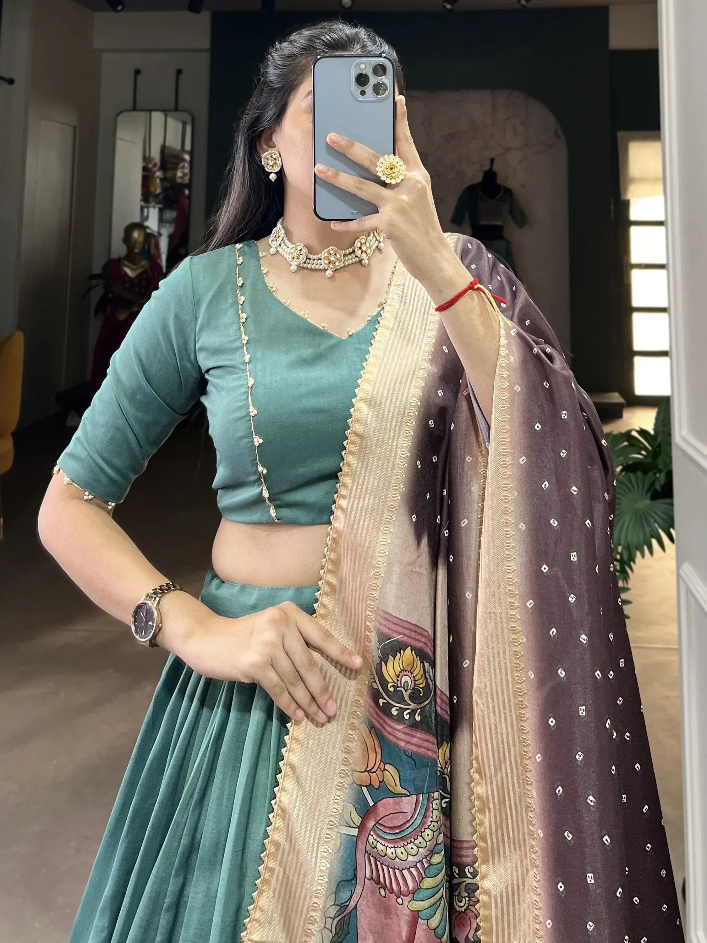 Woman in teal velvet lehenga choli with printed dupatta, traditional Indian ethnic wear