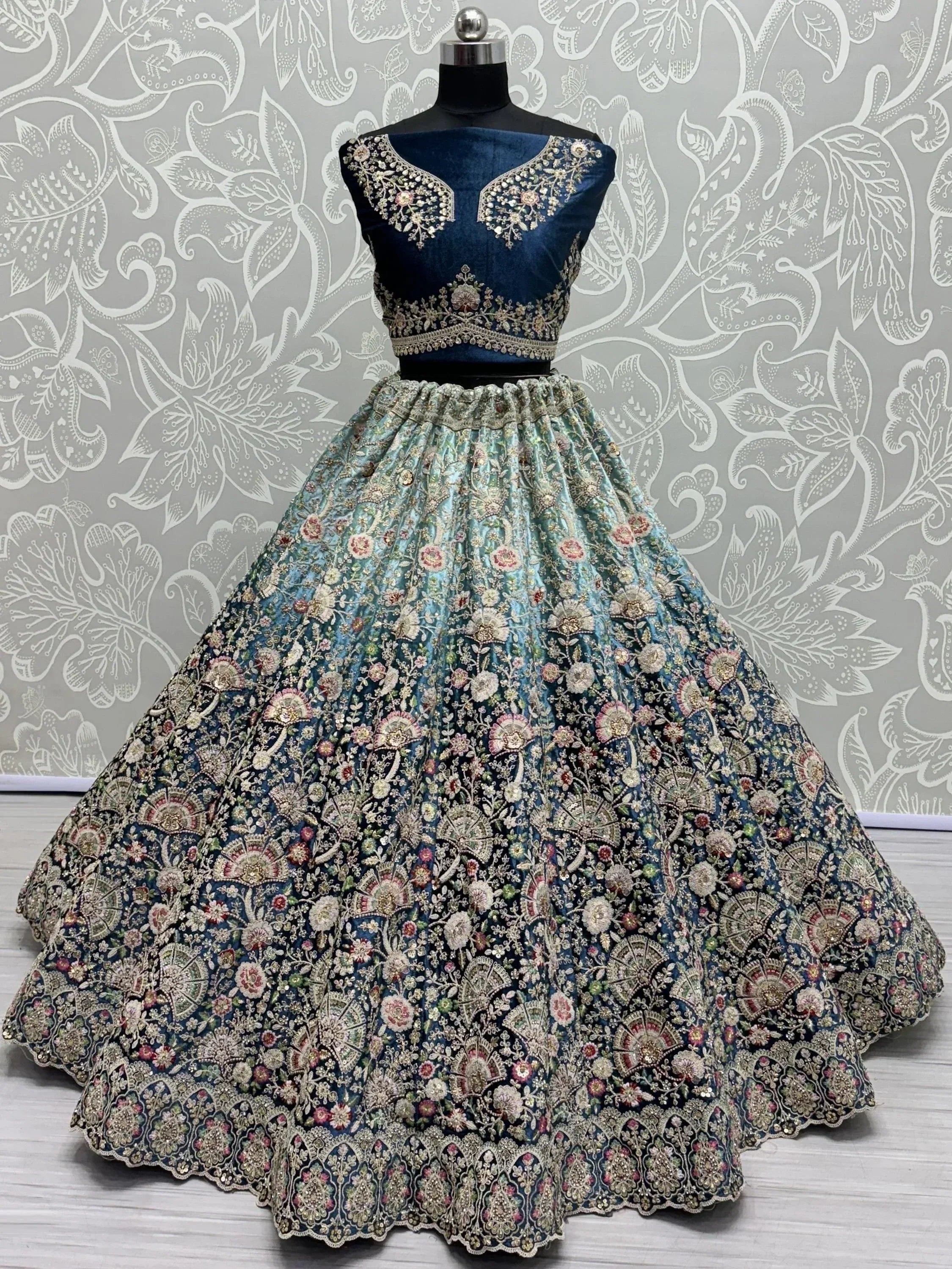 Blue velvet designer lehenga choli with heavy floral embroidery, perfect for Indian weddings and festive occasions.