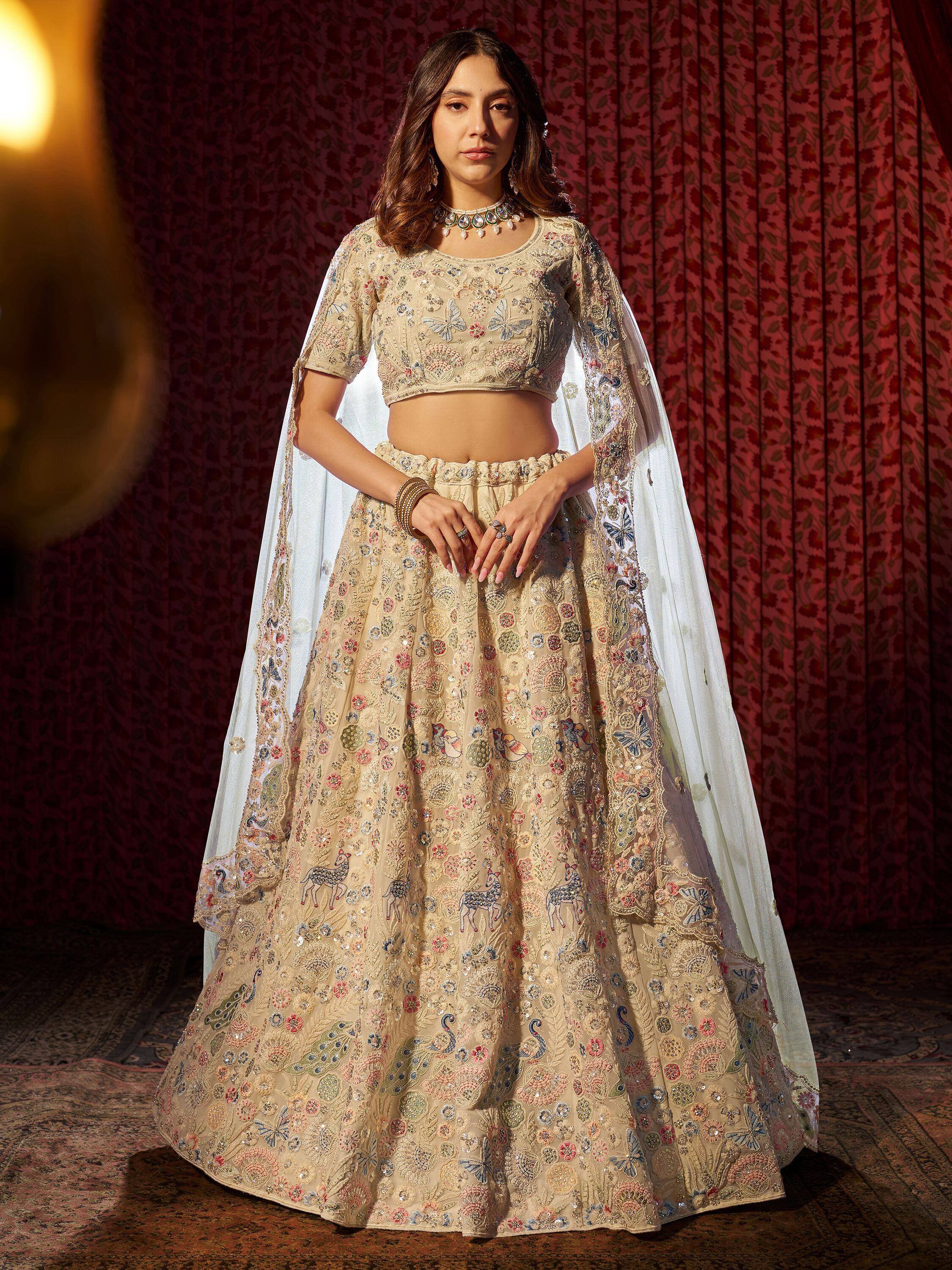 Beige embroidered lehenga choli with floral and animal motifs, sheer dupatta, perfect for Indian weddings or festive occasions.