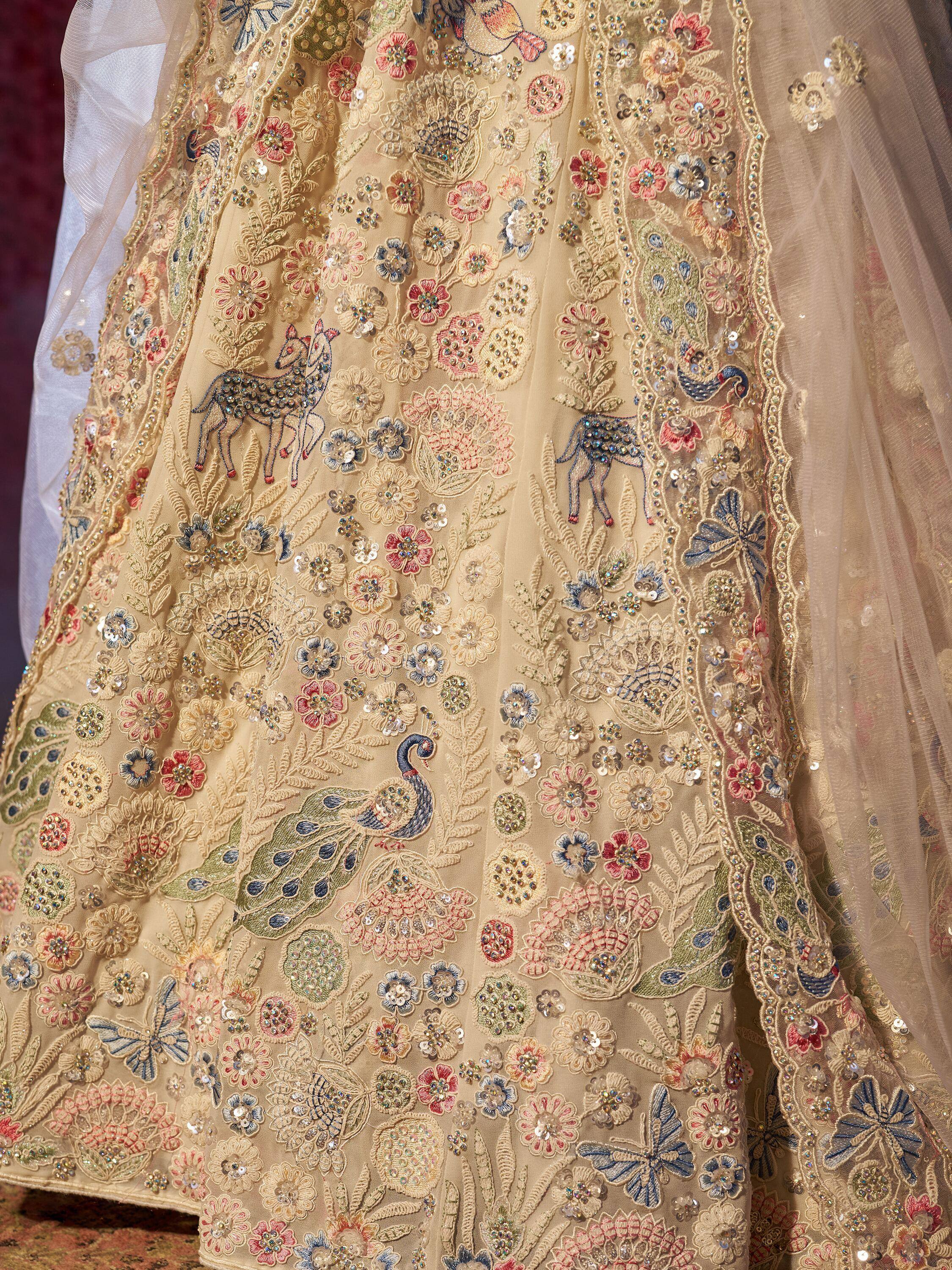 Beige designer lehenga with floral, peacock & deer embroidery, sequins, and net overlay for Indian ethnic wear