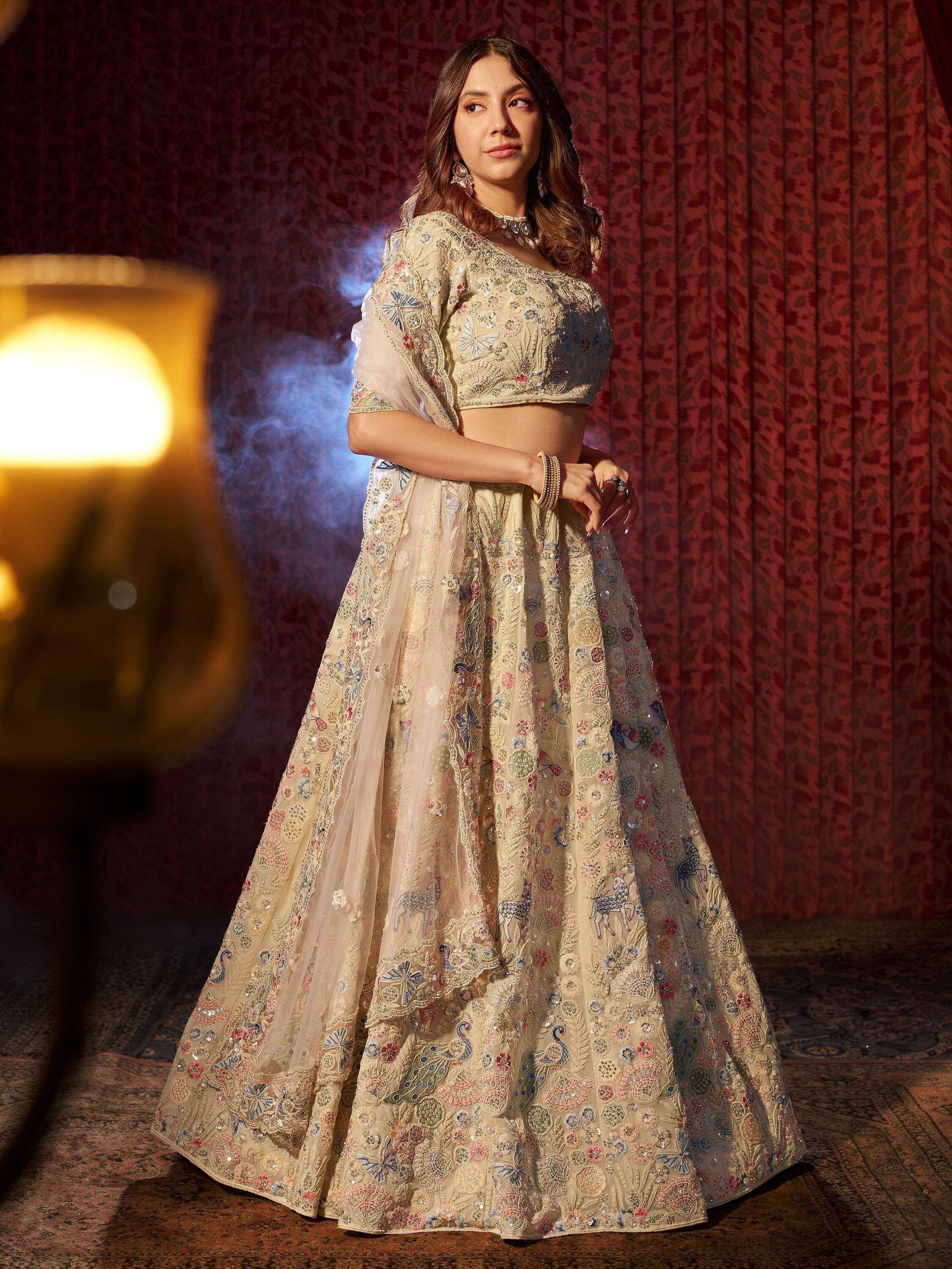 Elegant beige lehenga choli with floral and peacock embroidery, perfect for Indian weddings and festive occasions.