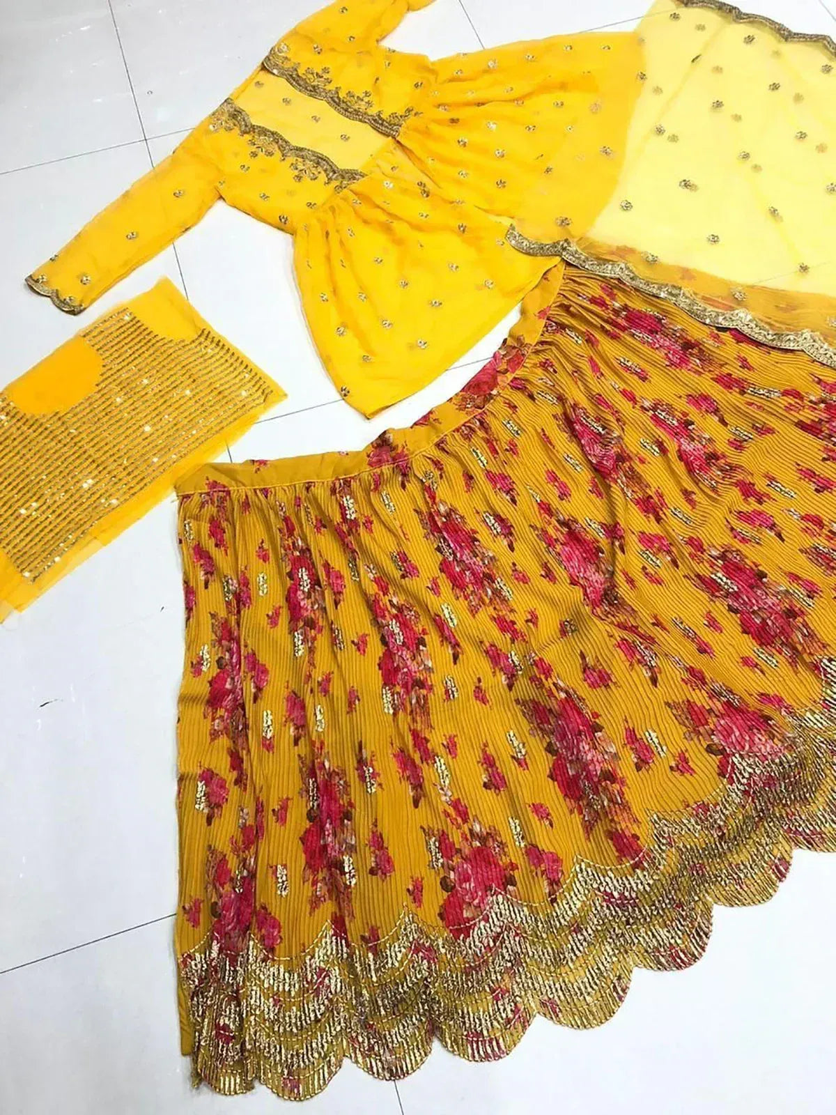 Yellow floral print pleated skirt with gold embroidery, matching top and dupatta for Indian ethnic wear
