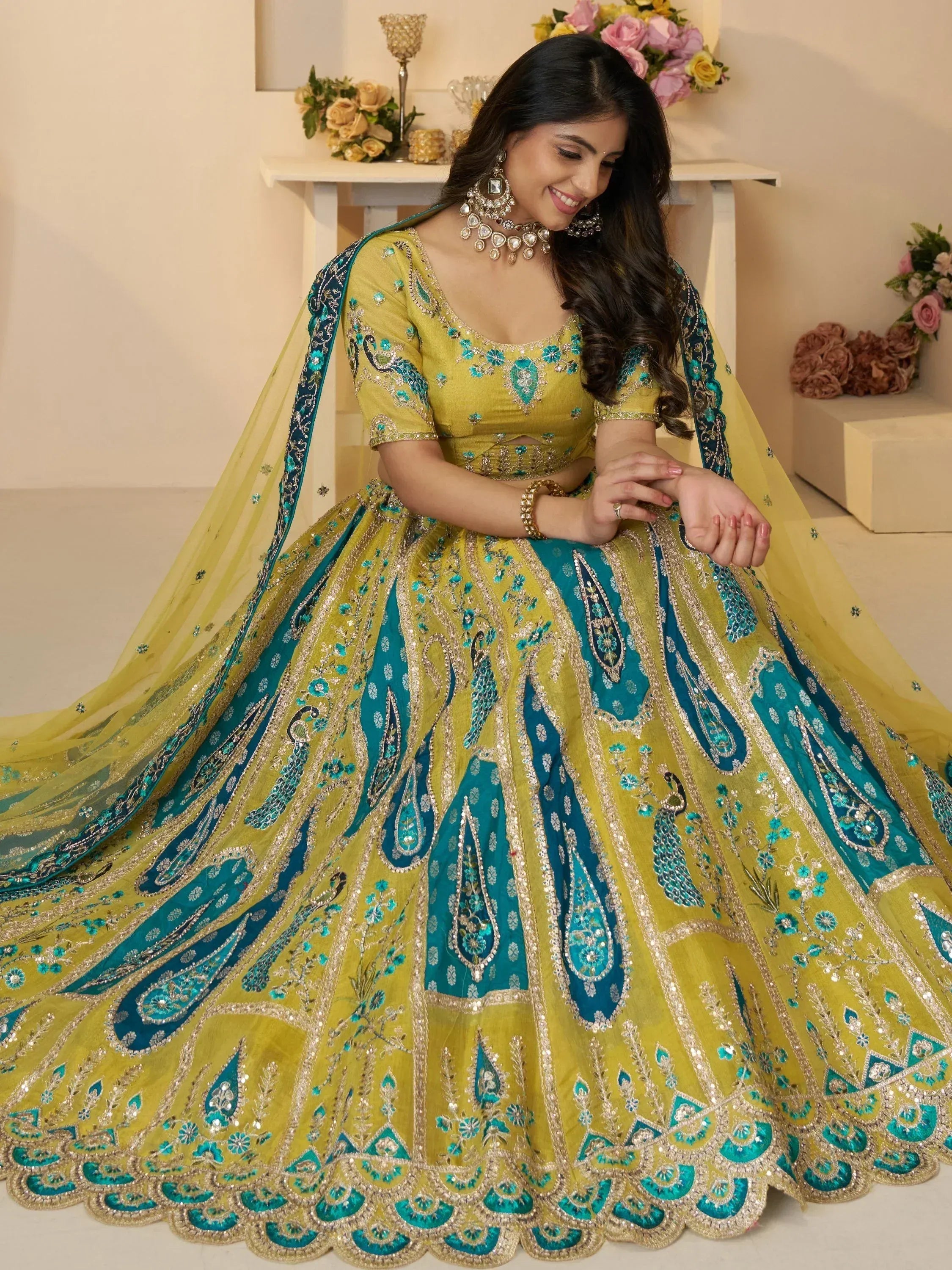 Yellow and teal designer lehenga choli with peacock embroidery, perfect for Indian weddings and festive occasions.