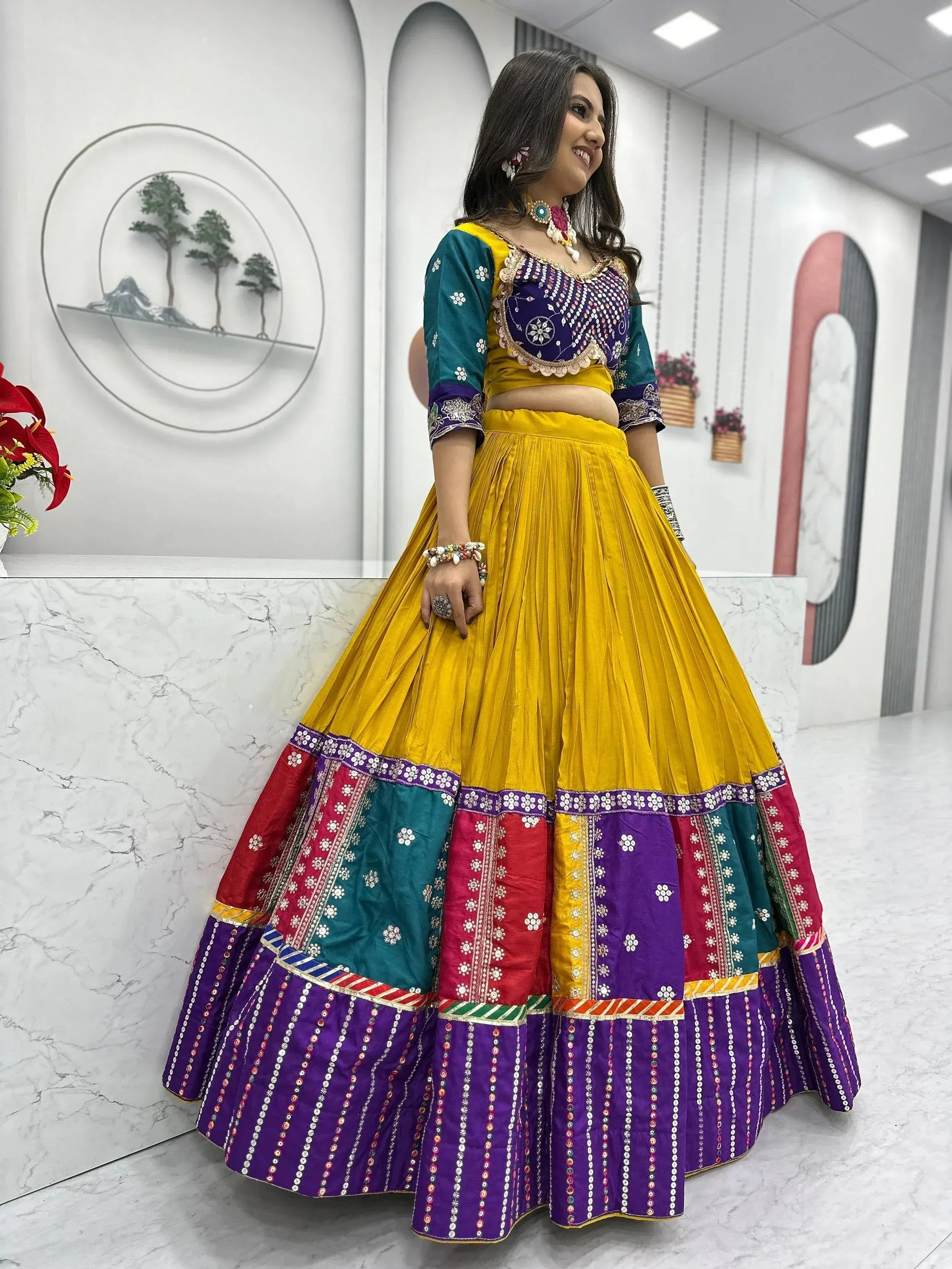 Vibrant yellow and purple lehenga choli with intricate embroidery and mirror work, perfect for festive occasions.