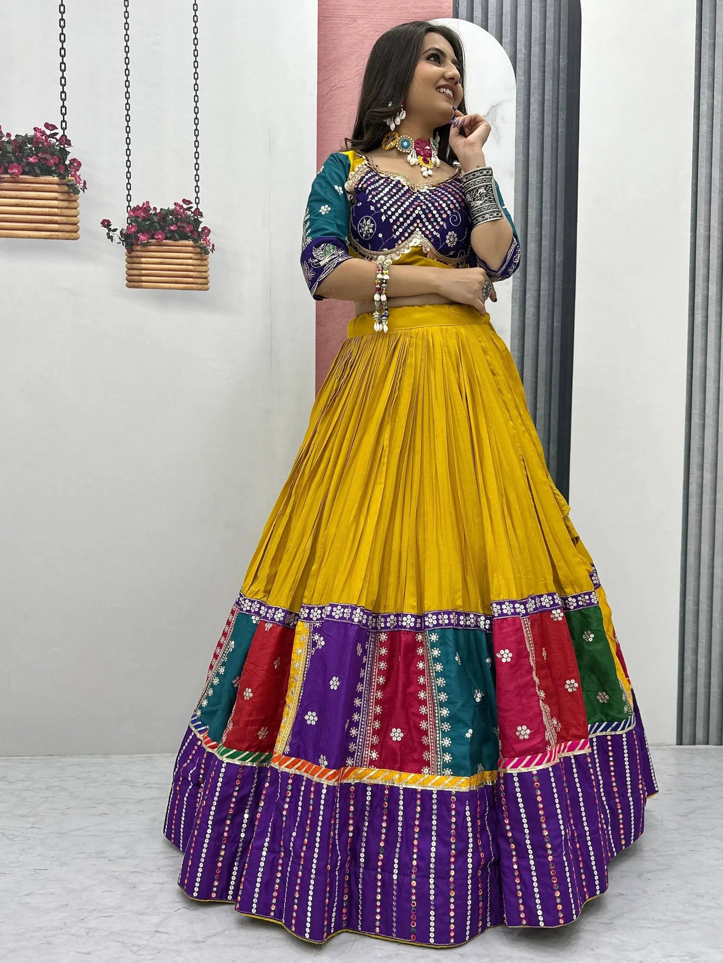 Vibrant yellow and purple lehenga choli with mirror work, perfect for Indian ethnic wear and festive occasions.