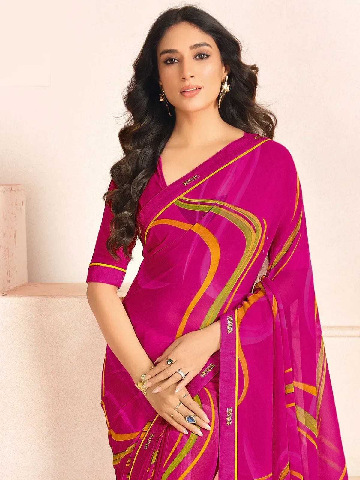 Vibrant magenta saree with gold and green abstract stripes, paired with matching blouse for ethnic wear