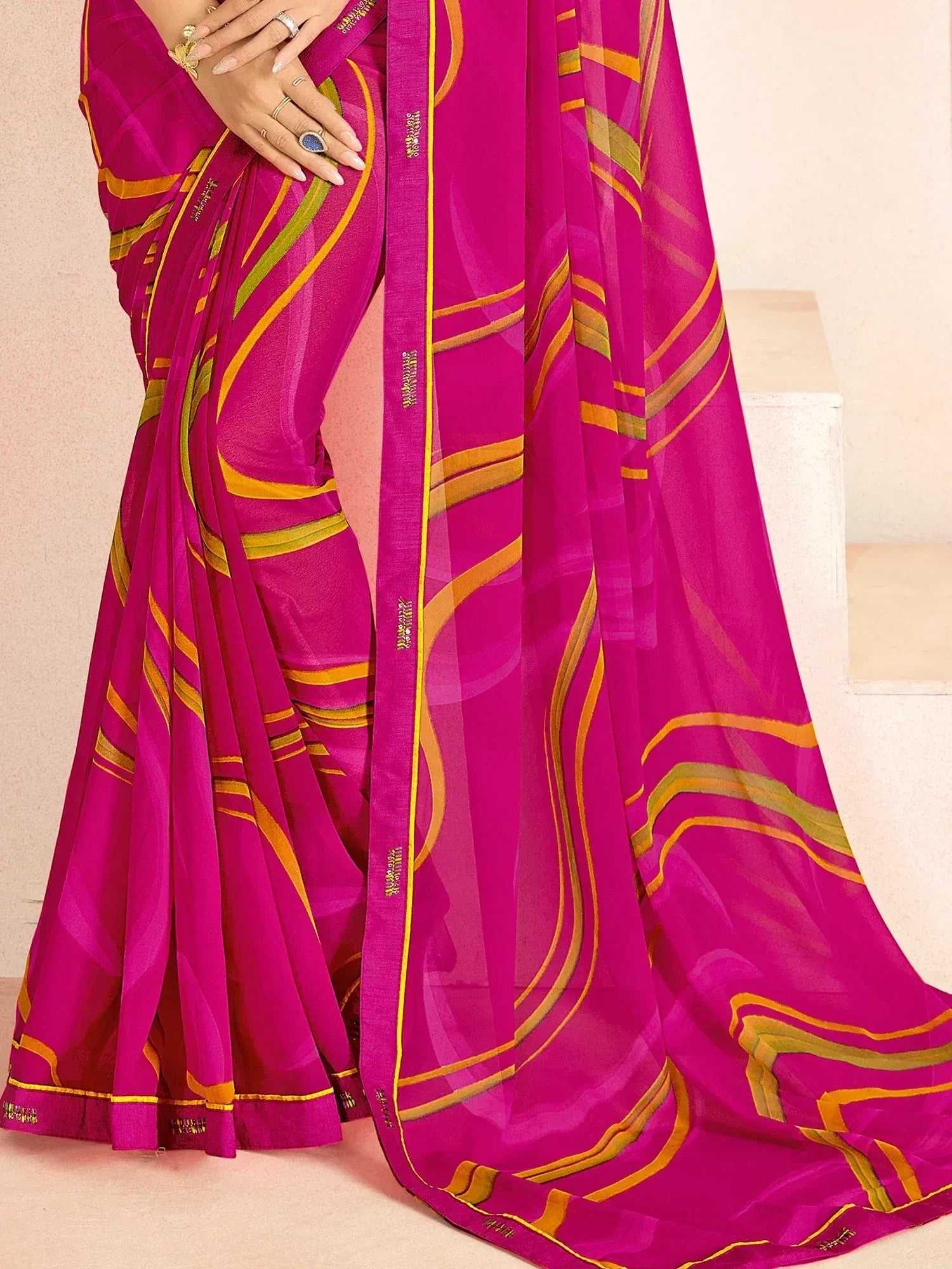 Vibrant pink saree with gold and green wavy stripes, perfect for Indian ethnic wear occasions