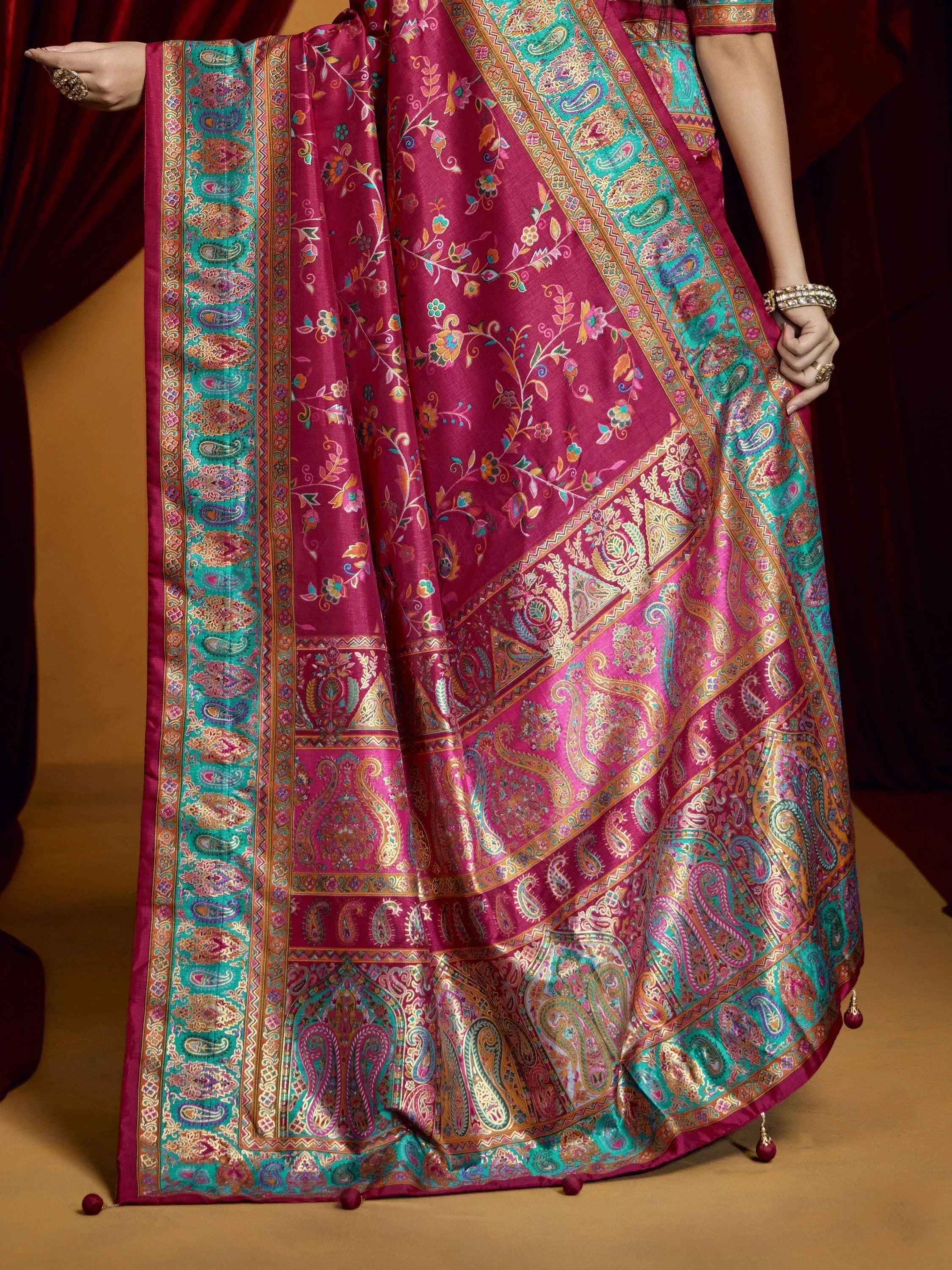 Luxury pink and teal paisley saree with intricate floral embroidery and golden borders, perfect for Indian ethnic wear.