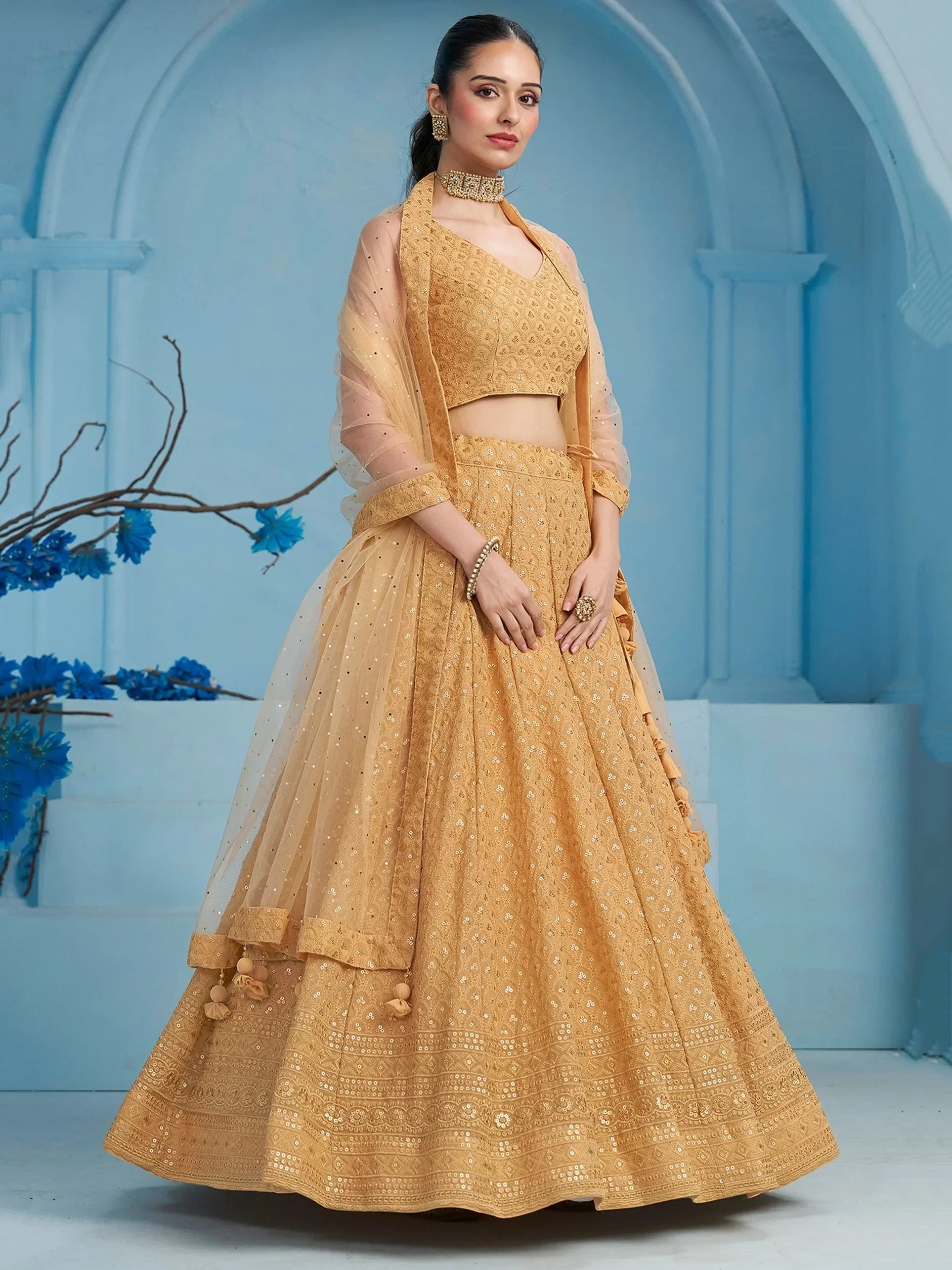 Golden embroidered lehenga choli with sheer dupatta, perfect for Indian weddings and festive occasions