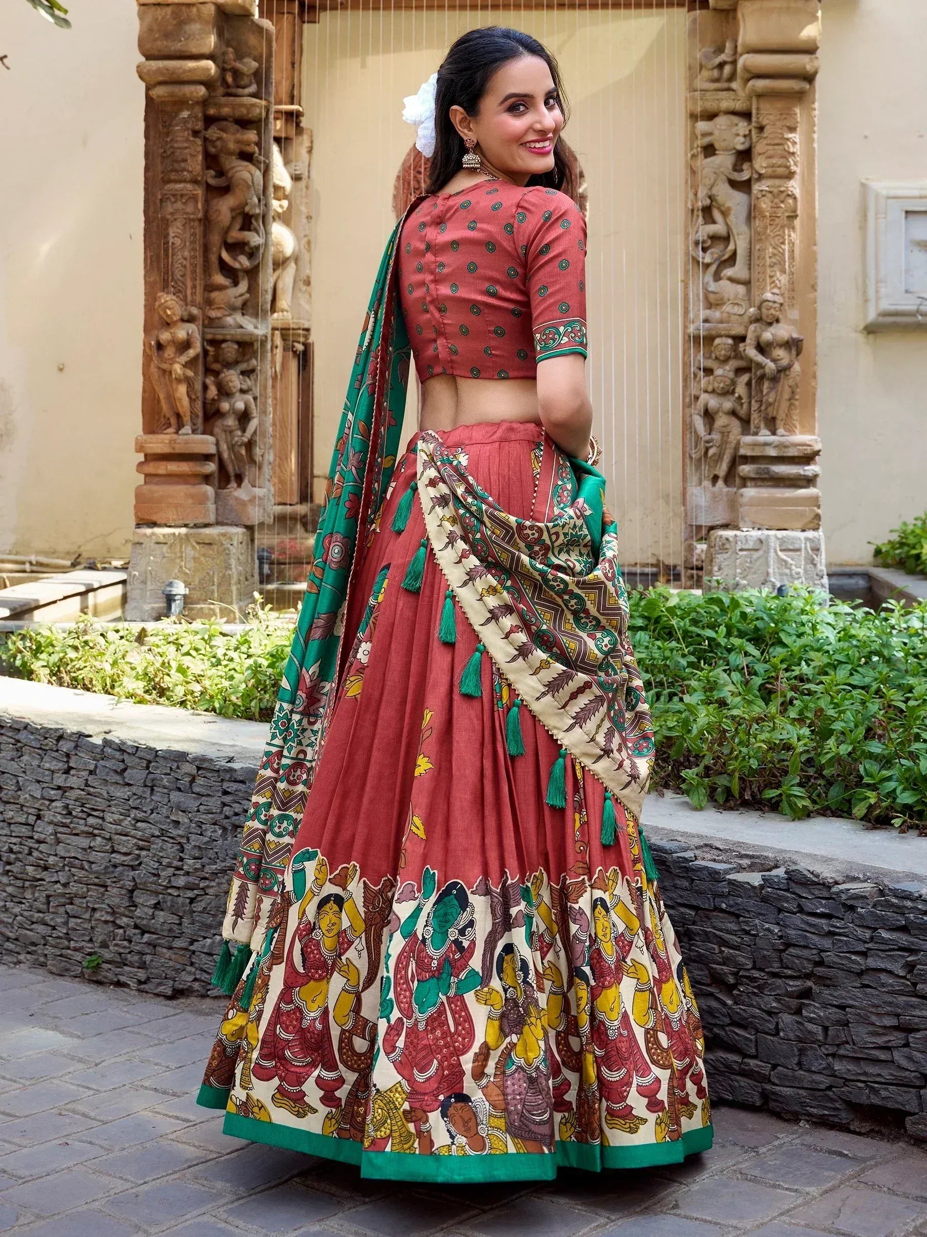 Woman in red printed lehenga choli with green dupatta, traditional Indian ethnic wear for festive occasions