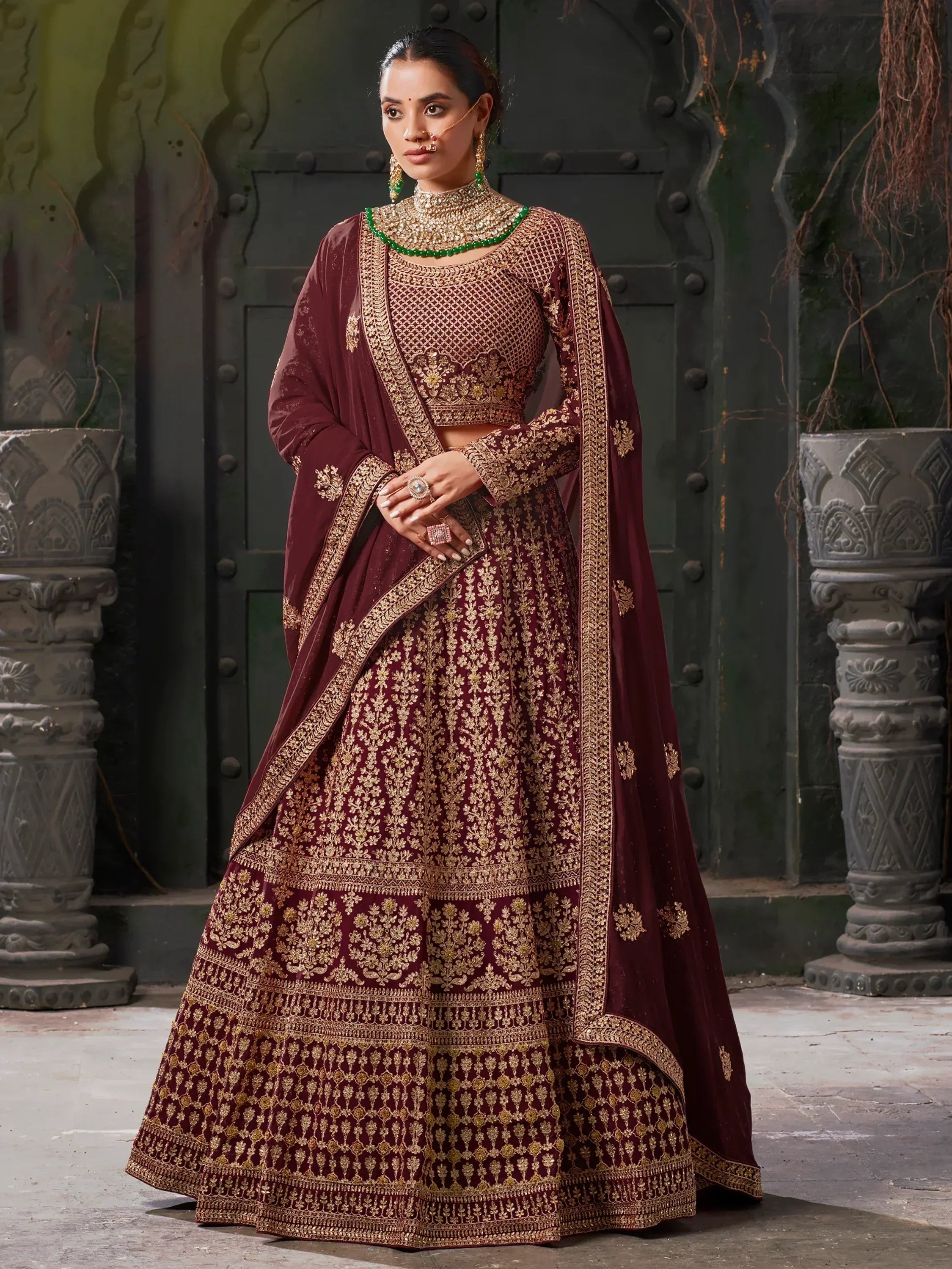 Maroon designer lehenga choli with gold embroidery, perfect for Indian weddings and festive occasions.