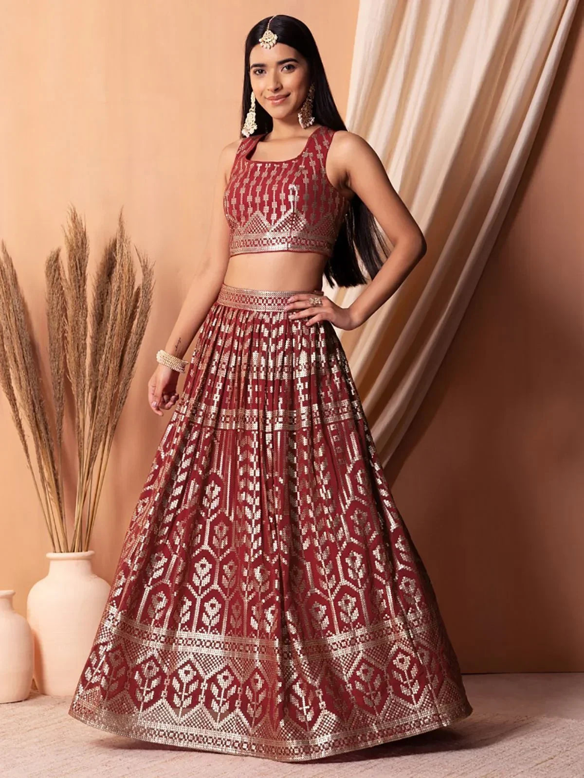 Maroon and gold embroidered lehenga choli with geometric patterns, perfect for Indian ethnic occasions.