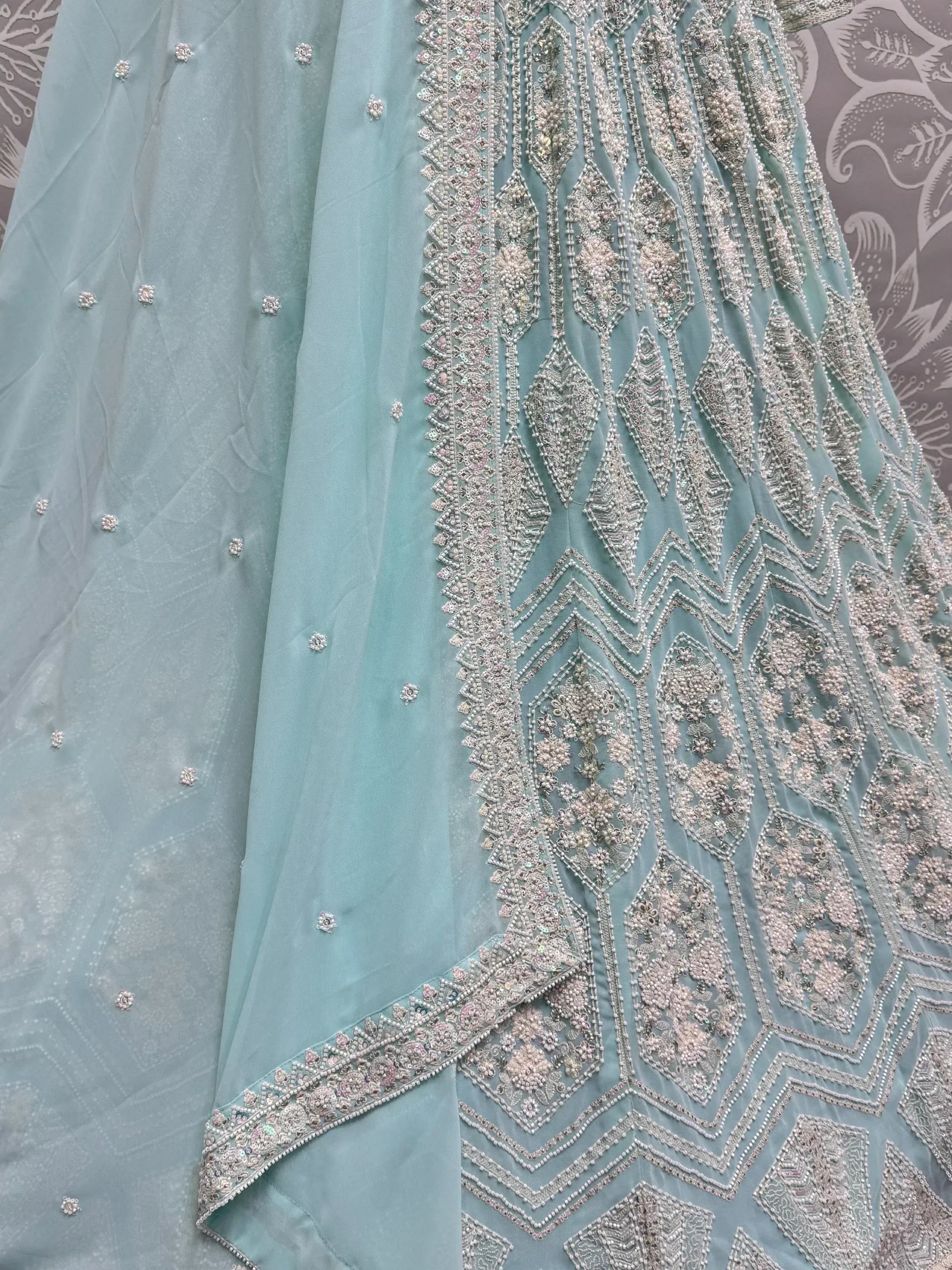 Mint green designer lehenga with intricate silver and pink beadwork, perfect for Indian ethnic wear.