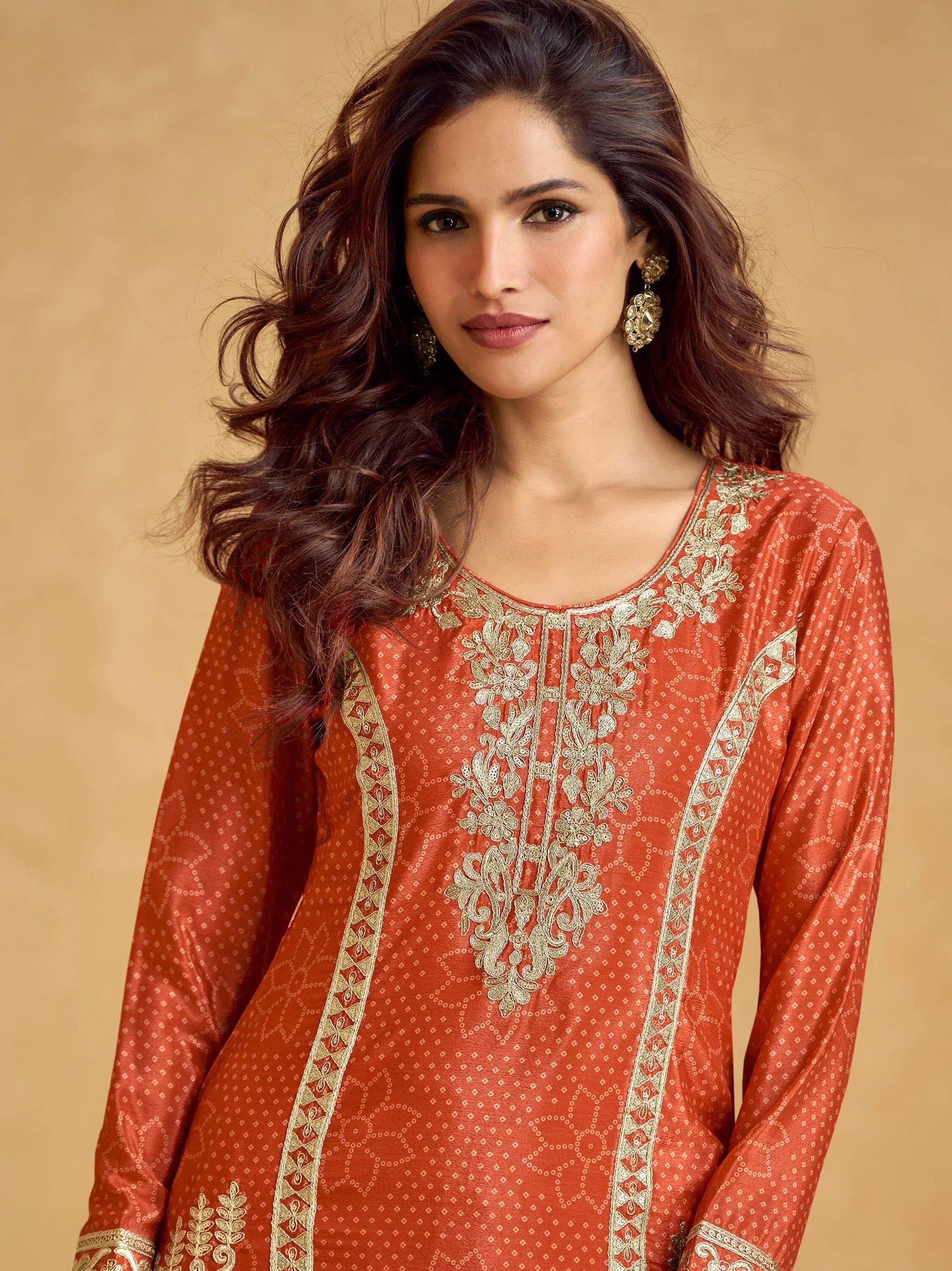 Woman in orange ethnic kurti with gold embroidery, perfect for Indian wear occasions