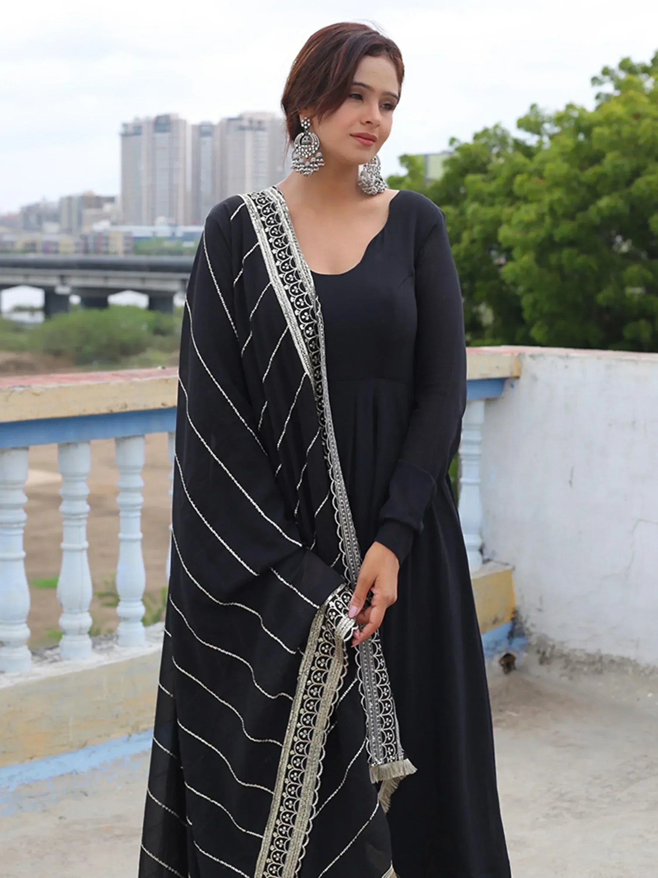 Black ethnic gown with silver embroidery, perfect for Indian wear, paired with statement earrings.