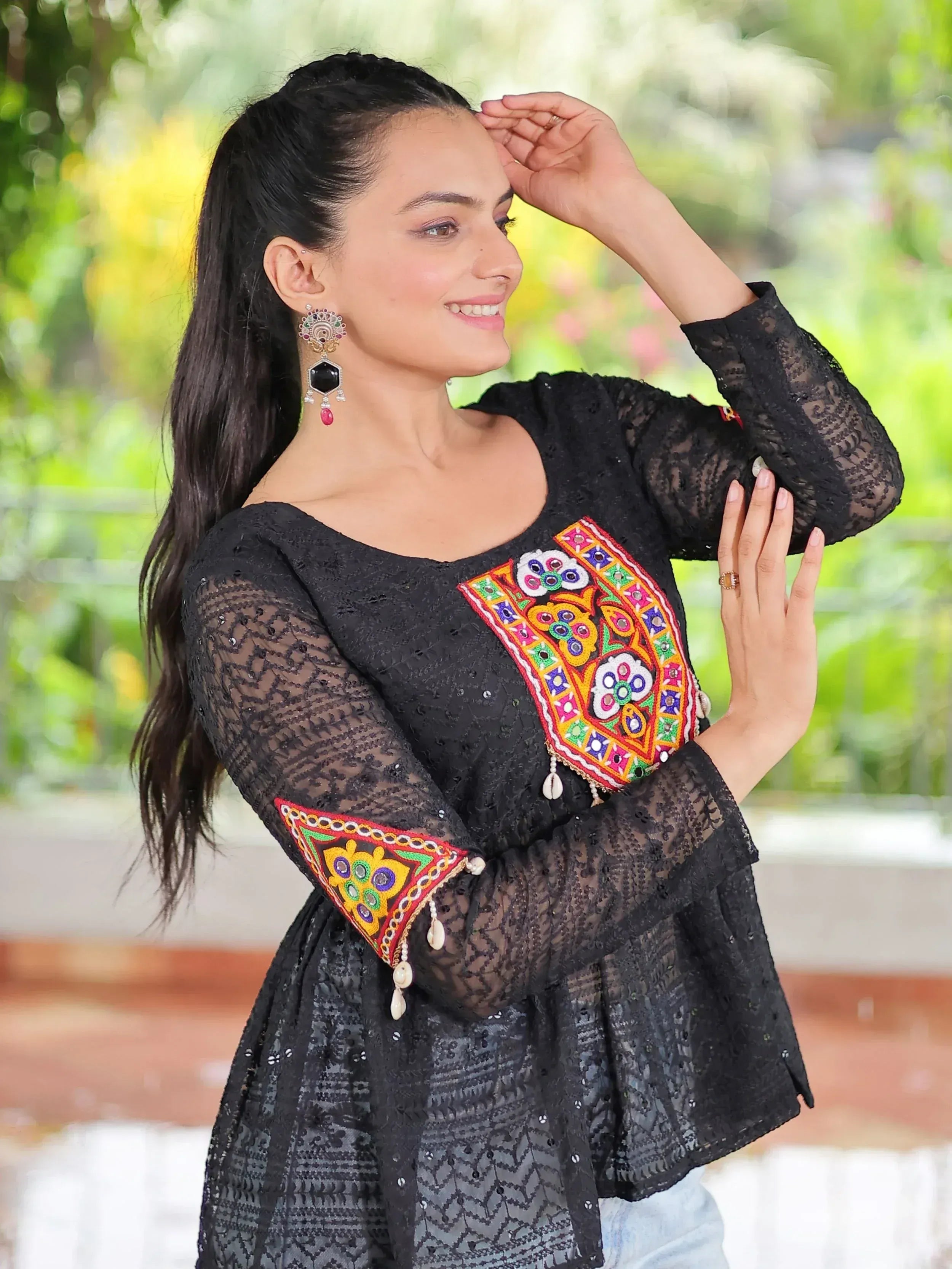 Black lace ethnic top with colorful mirror embroidery and bell sleeves, paired with statement earrings
