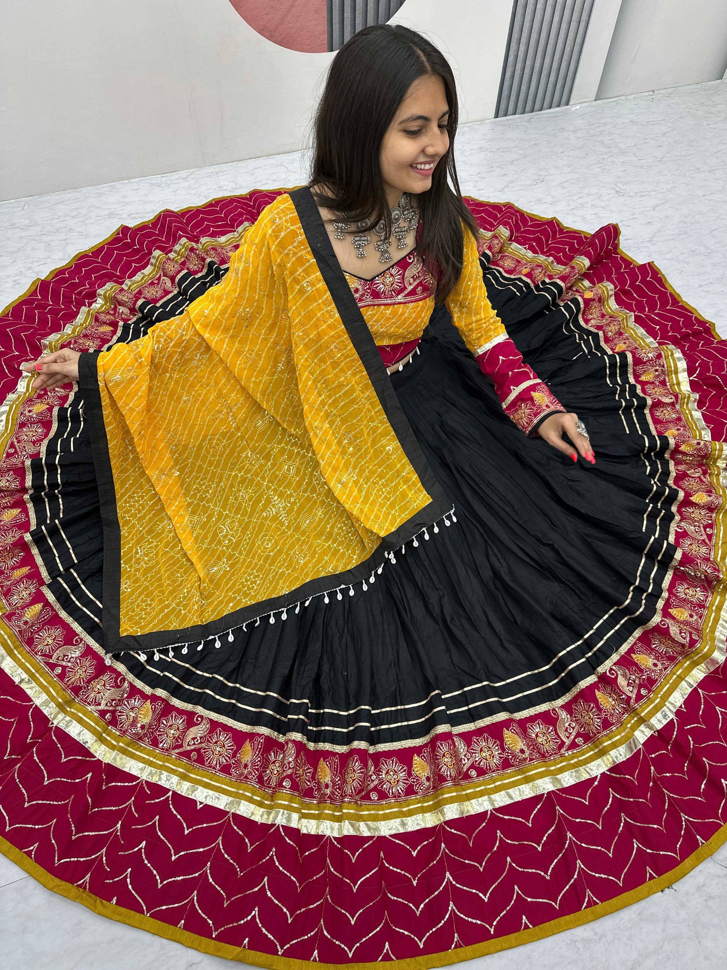 Woman in black and maroon embroidered lehenga with yellow dupatta, Indian ethnic wear