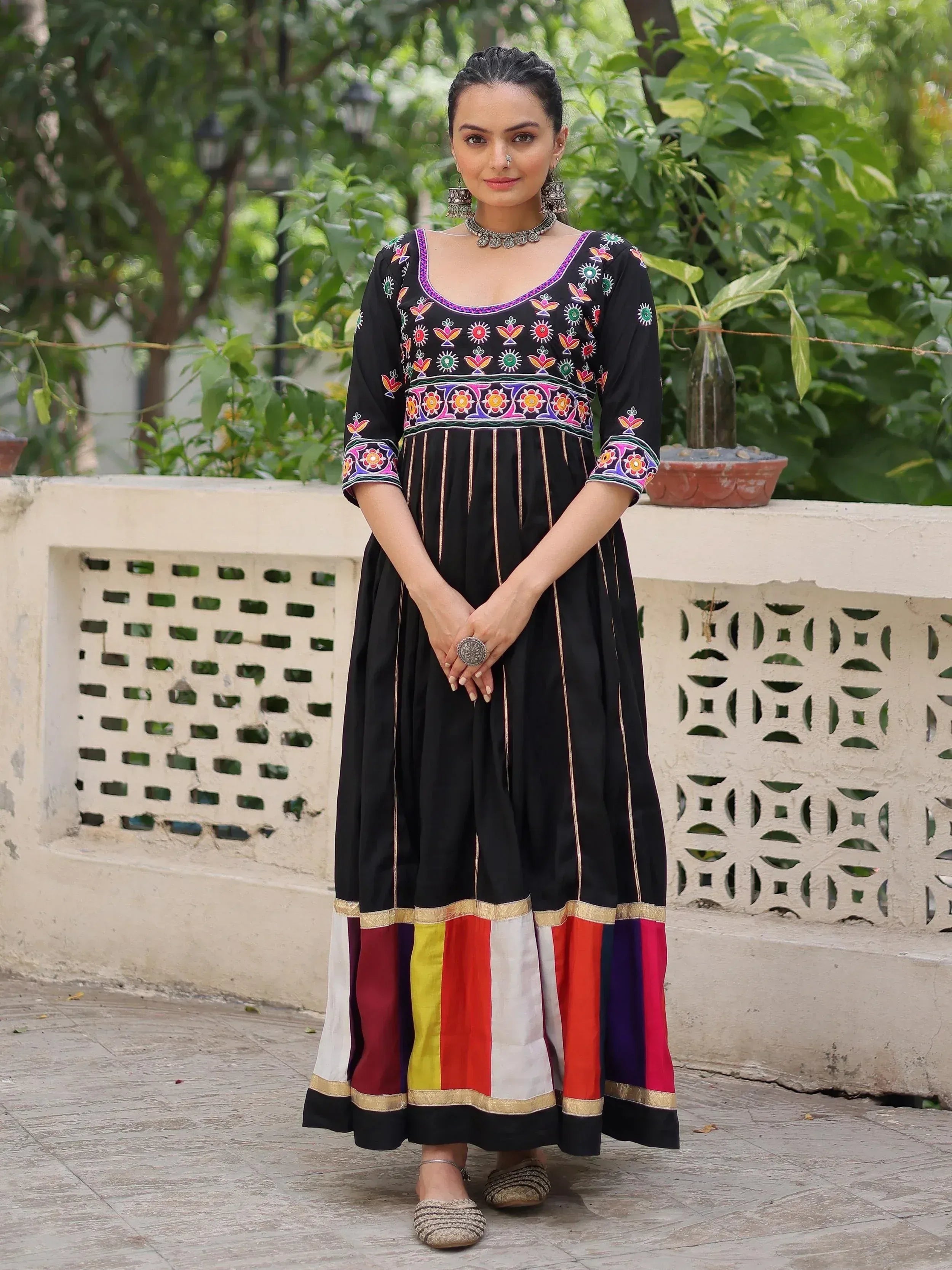 Black embroidered ethnic gown with colorful floral patterns and striped hem, perfect for Indian wear