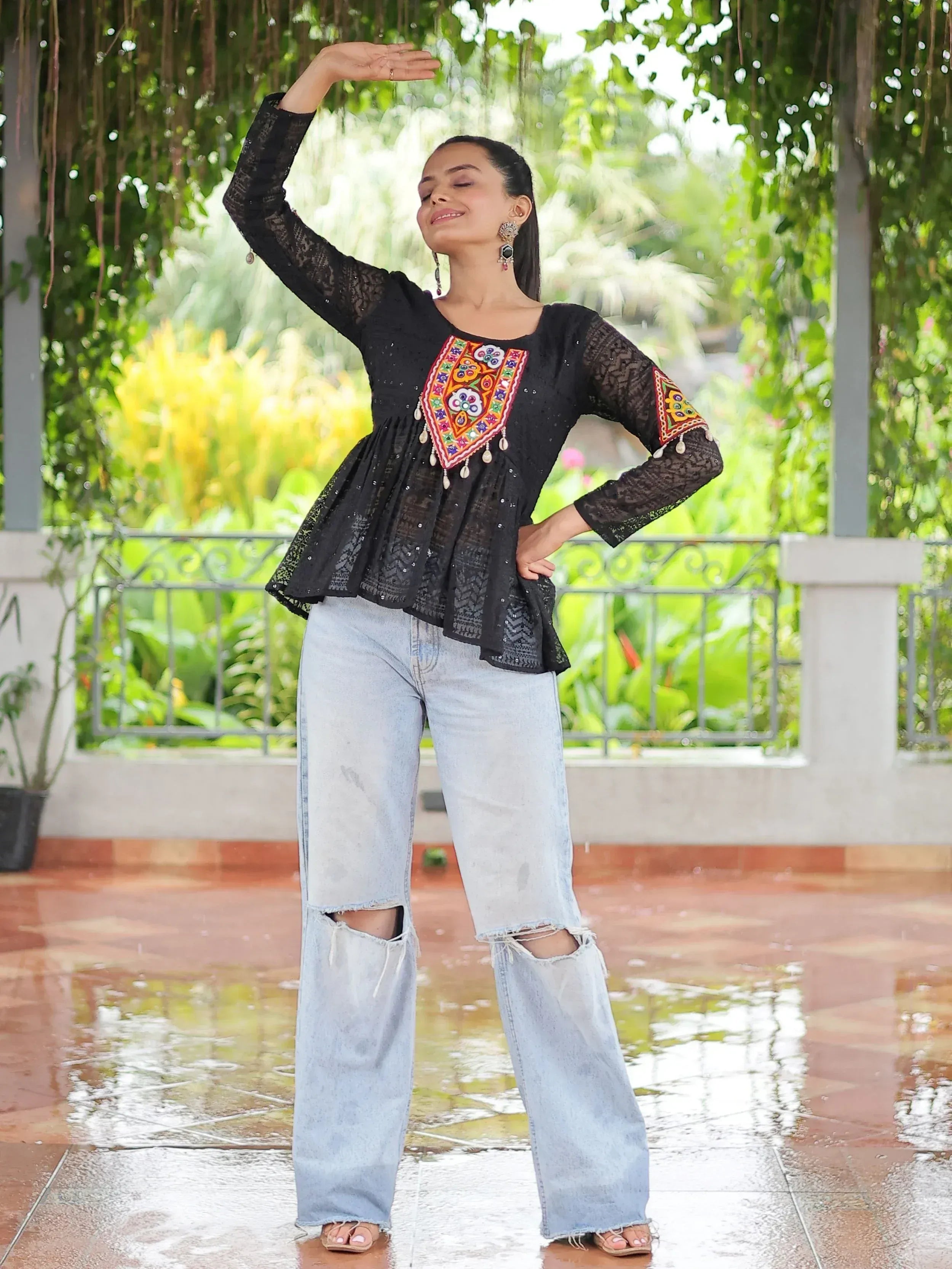 Black embroidered ethnic top with lace sleeves paired with ripped jeans, perfect for casual Indian wear.