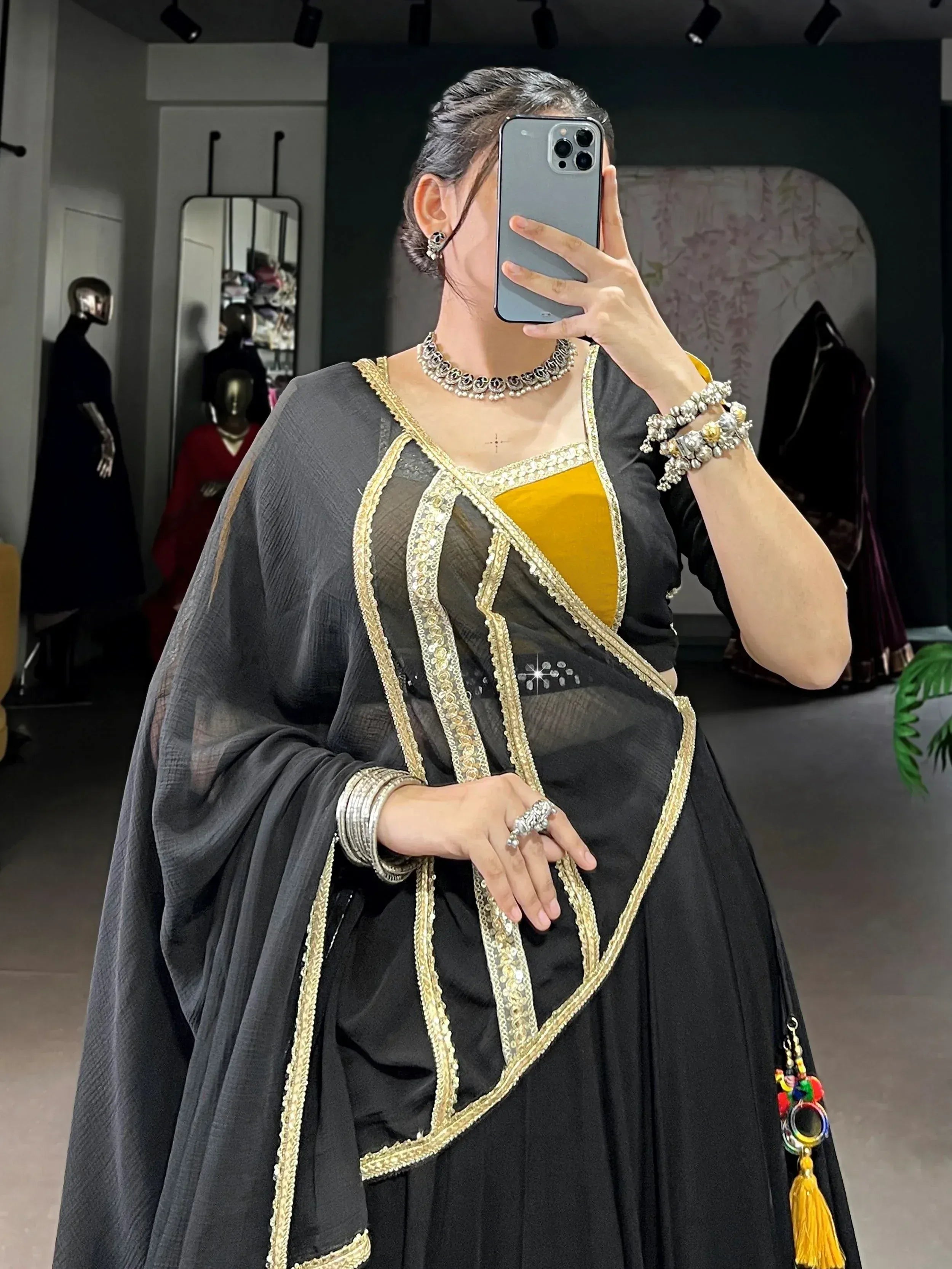 Black and gold ethnic gown with intricate embroidery and matching jewelry
