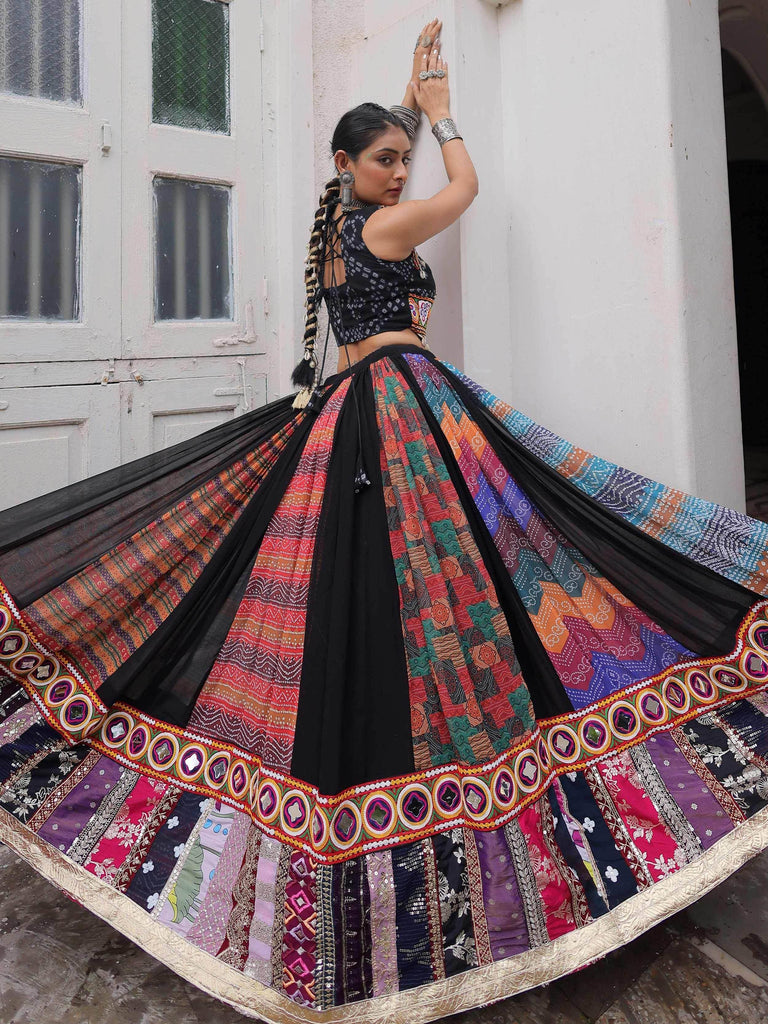 Woman in vibrant Indian ethnic lehenga choli with colorful patchwork skirt and black blouse, perfect for festive occasions.