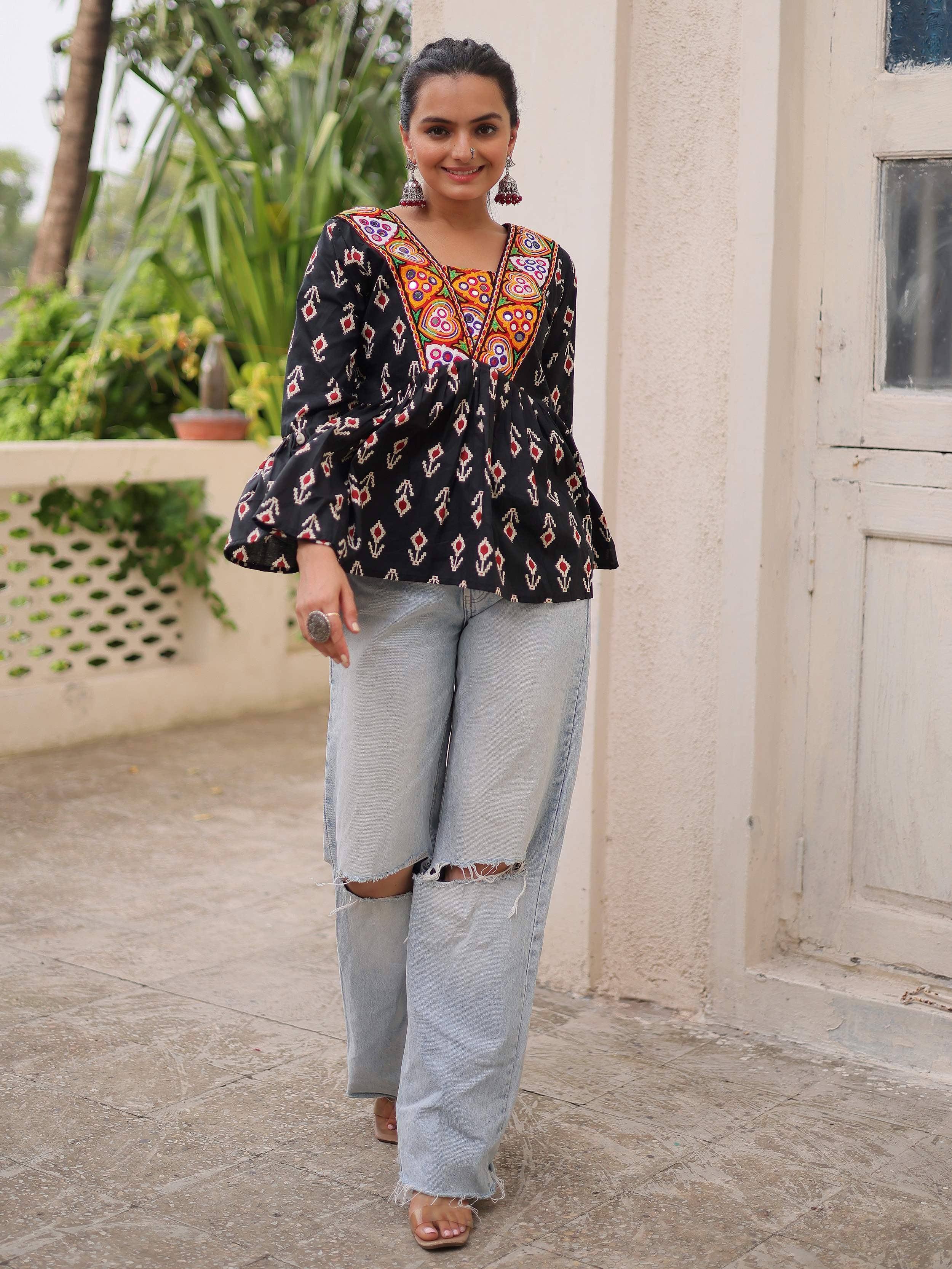 Black embroidered ethnic top with bell sleeves paired with ripped wide-leg jeans, perfect for casual Indian wear.