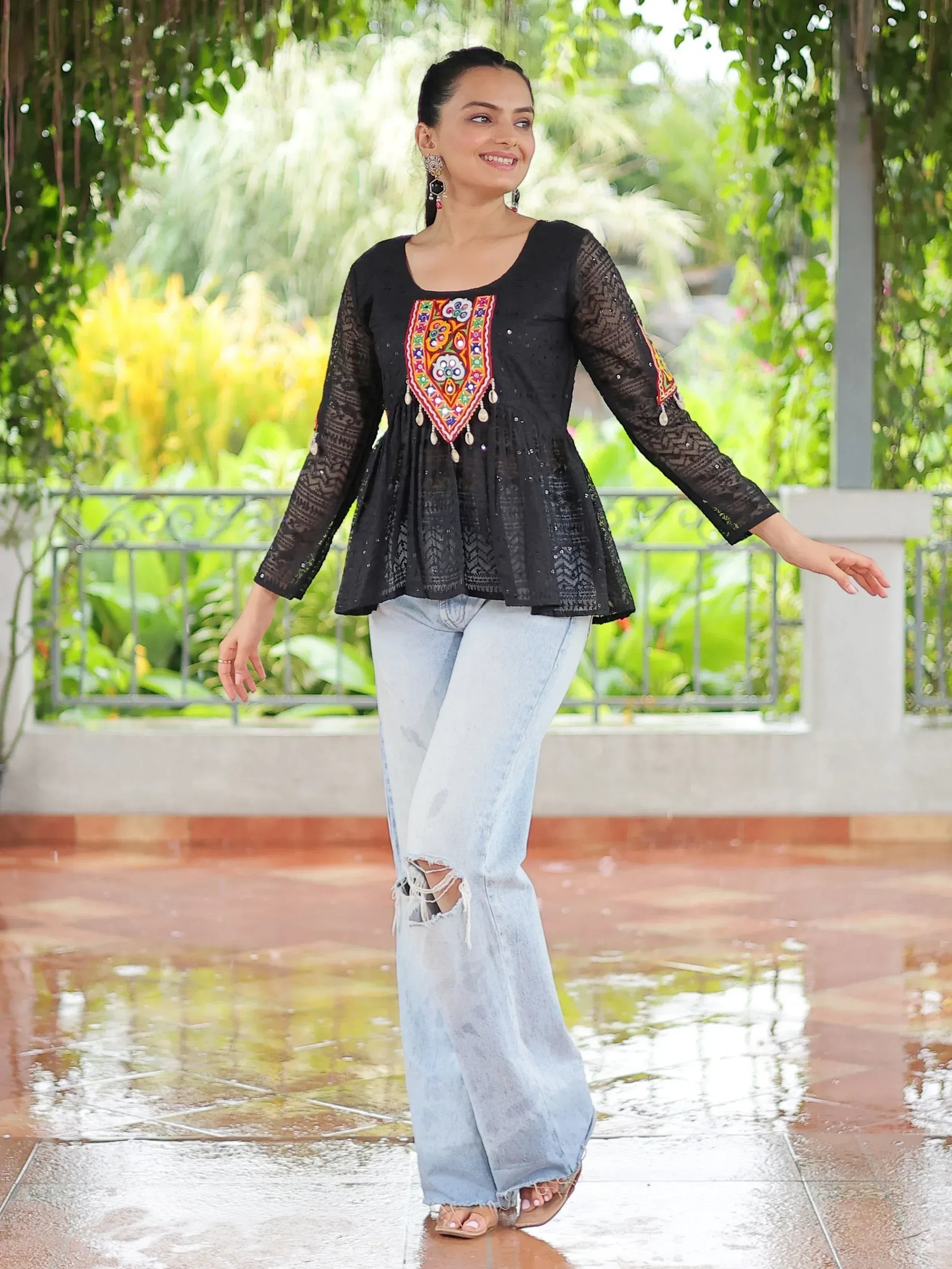 Black embroidered ethnic top with lace sleeves paired with ripped jeans, perfect for casual Indian wear.