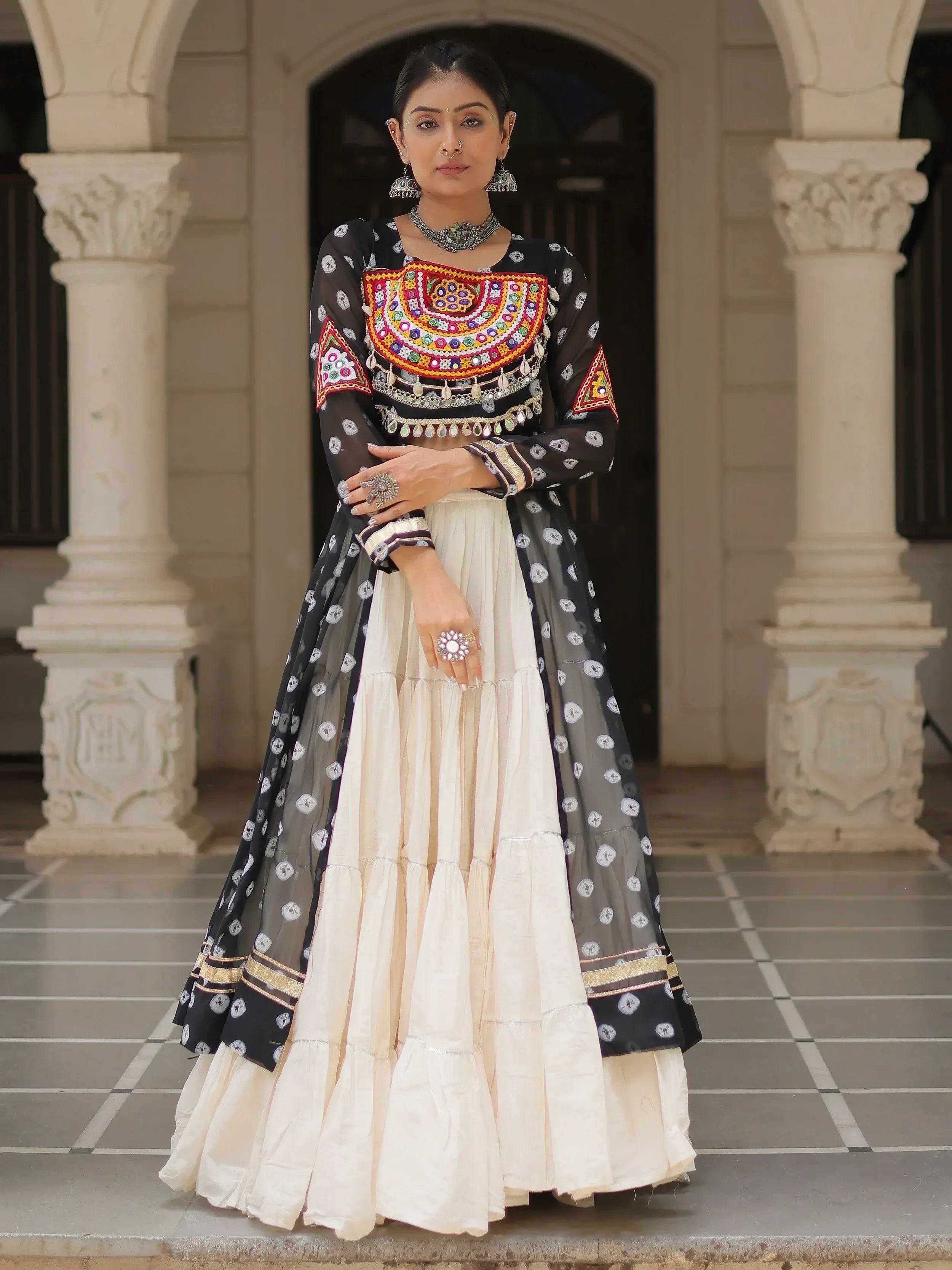 Black and cream ethnic lehenga with colorful mirror work and sheer dupatta, perfect for Indian weddings or festivals.