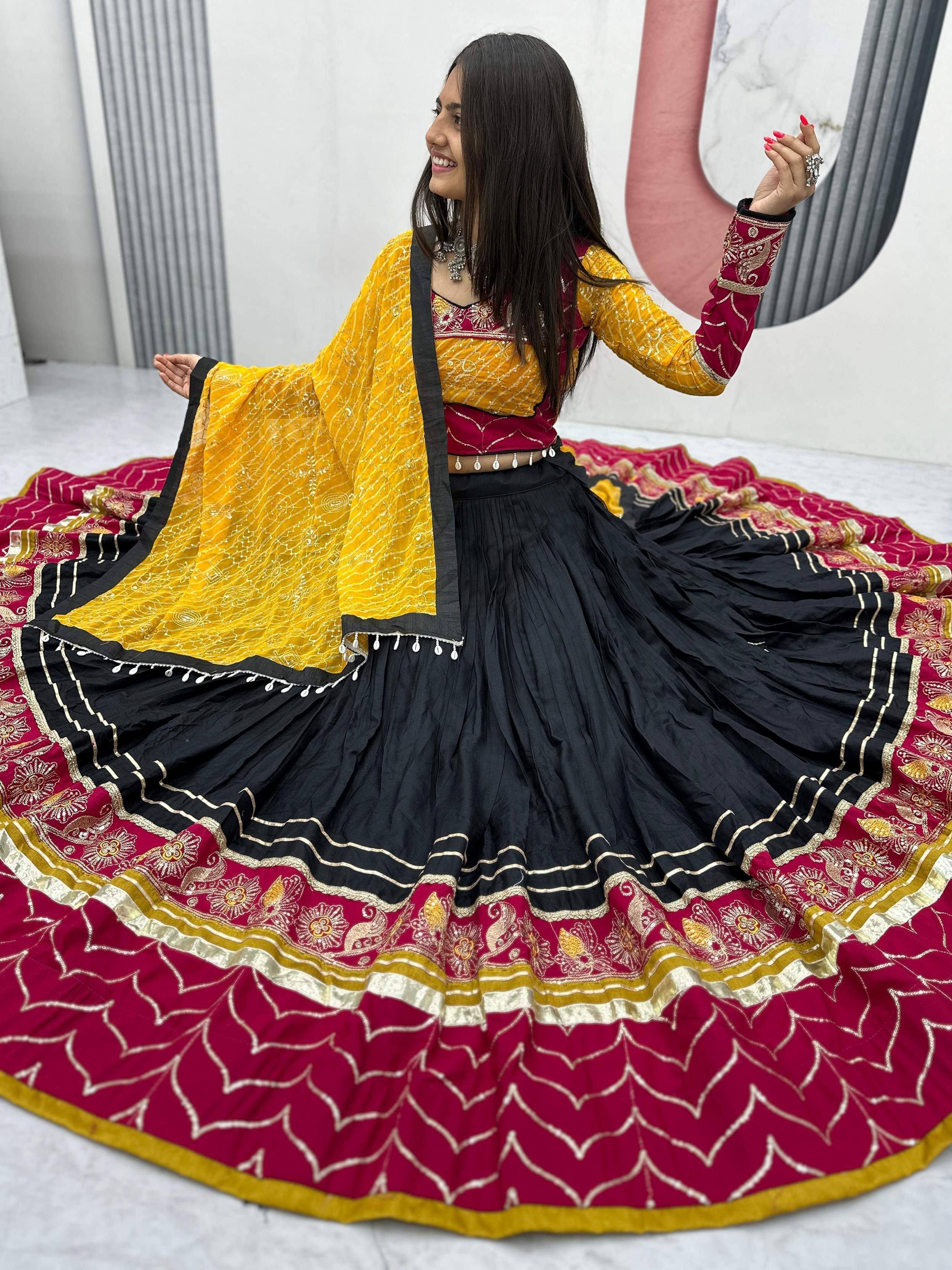 Woman in vibrant Indian ethnic wear: maroon and yellow embroidered lehenga choli with black skirt, perfect for festive occasions.