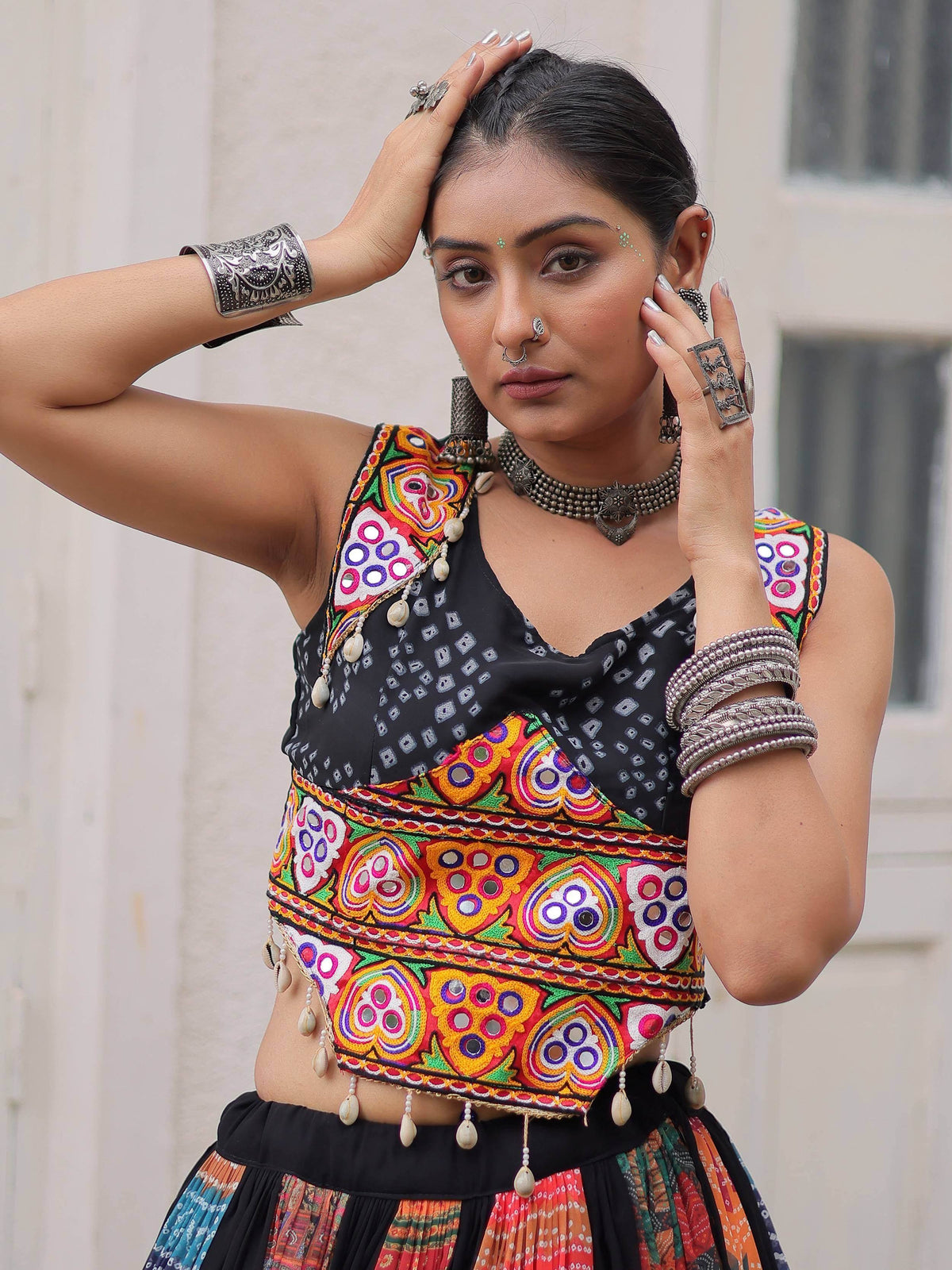 Woman in vibrant Indian ethnic wear with mirror work blouse and traditional jewelry