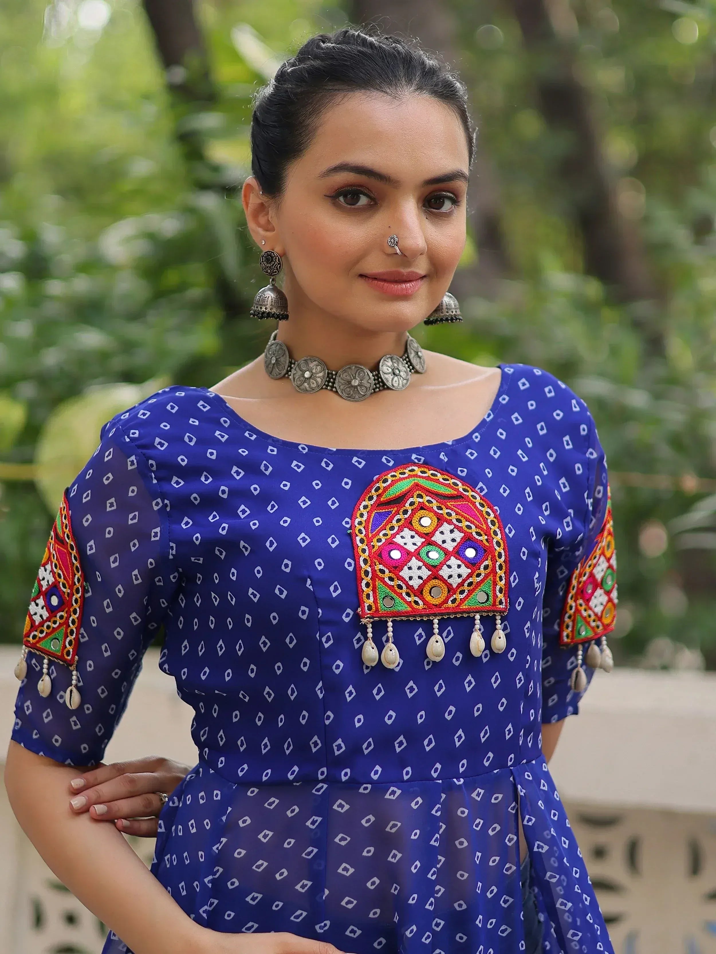 Blue ethnic gown with mirror work and embroidery, styled with traditional jewelry for Indian wear