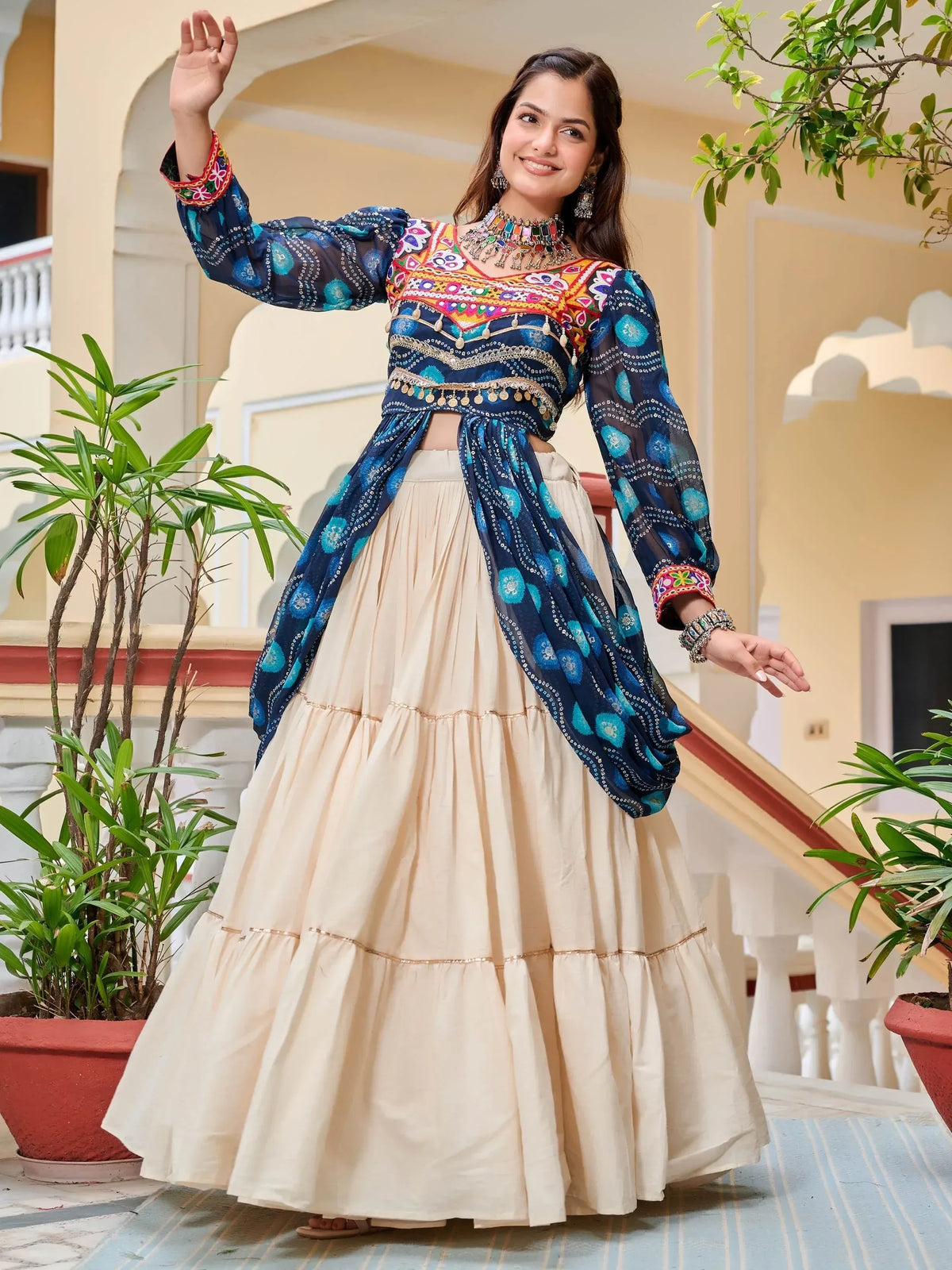 Woman in vibrant blue embroidered top with cream tiered skirt, traditional Indian ethnic wear