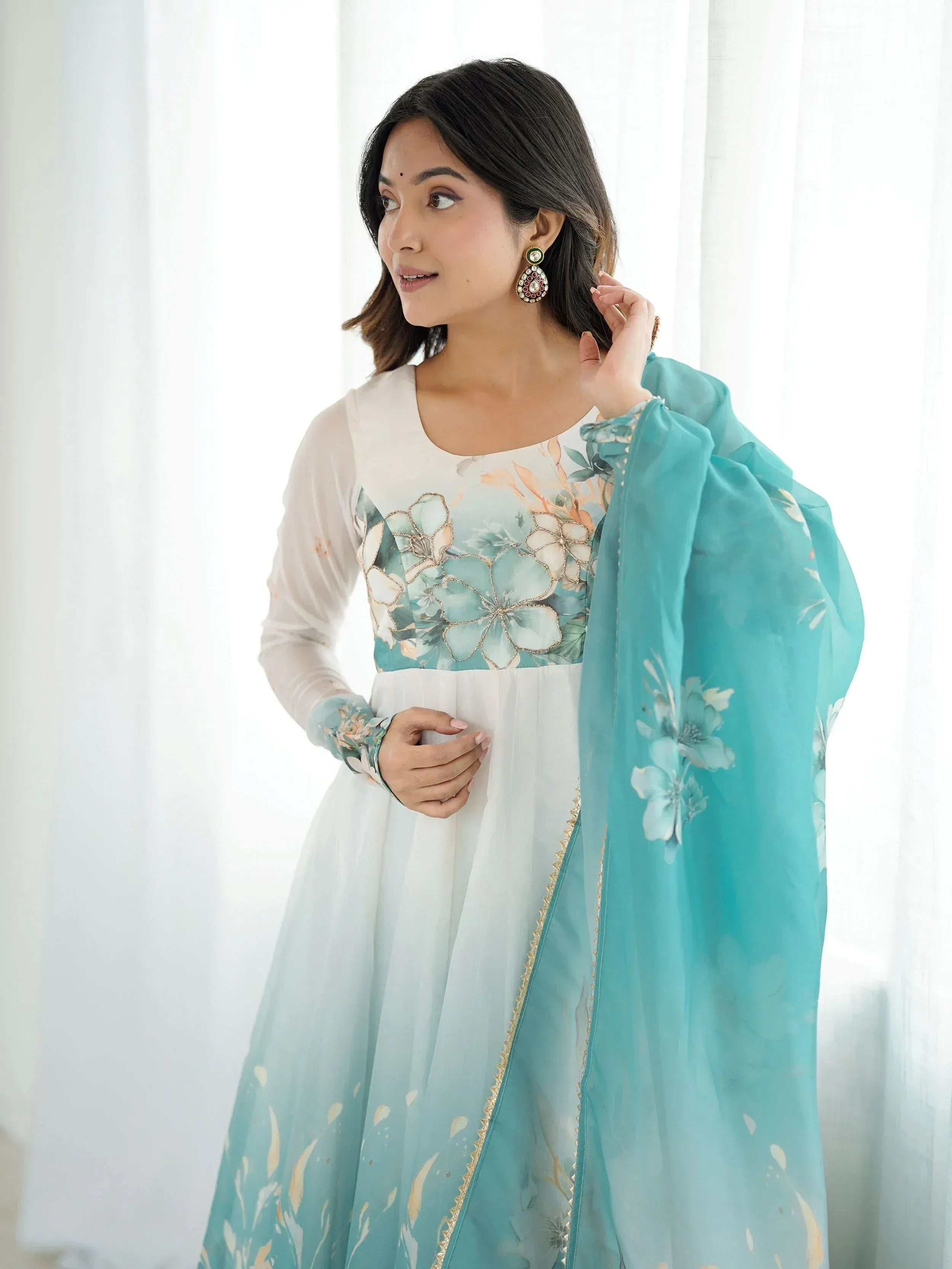 Woman in floral print Indian ethnic gown with turquoise dupatta, perfect for festive occasions