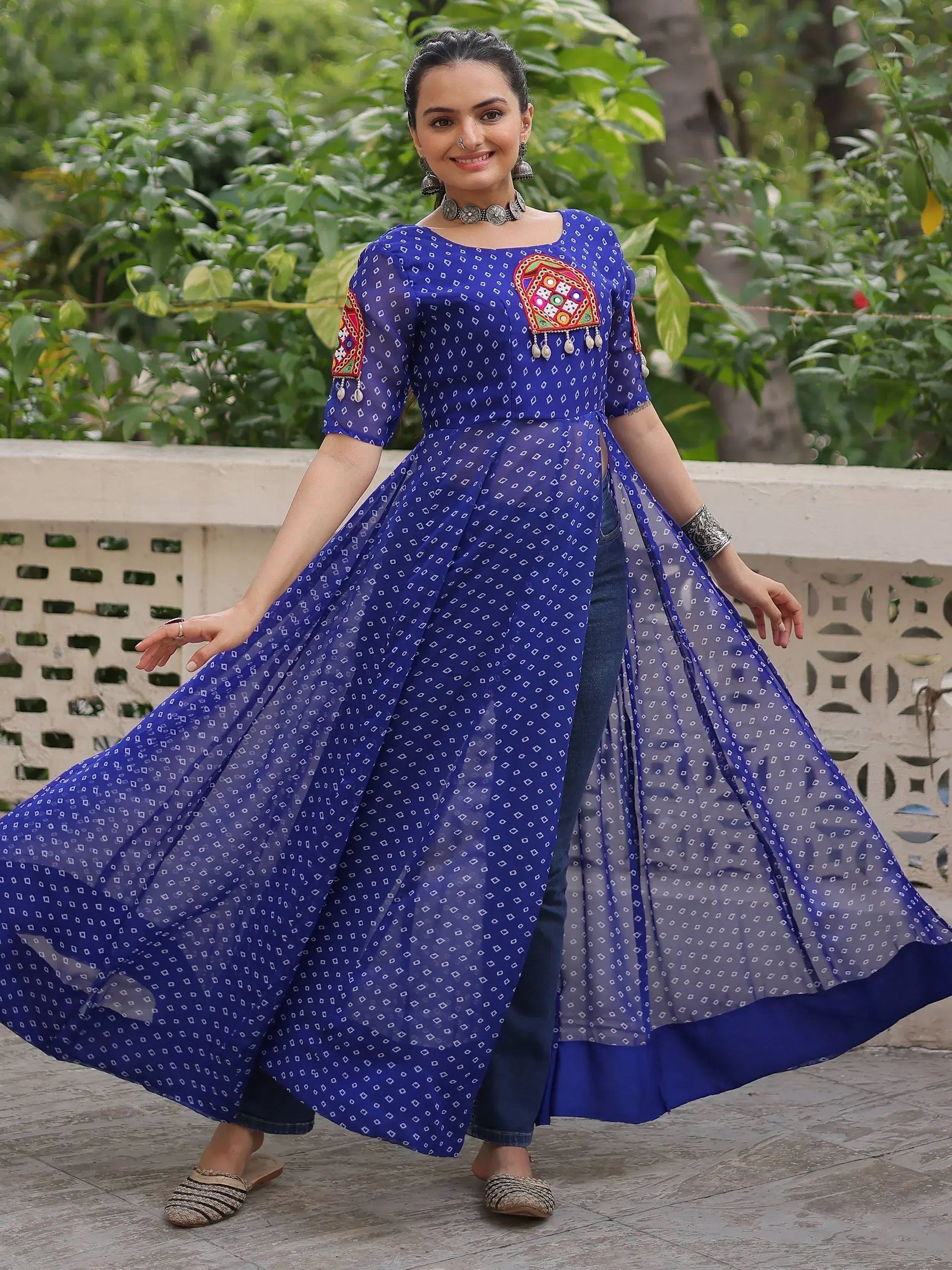 Blue printed ethnic gown with mirror work, paired with jeans, perfect for festive occasions