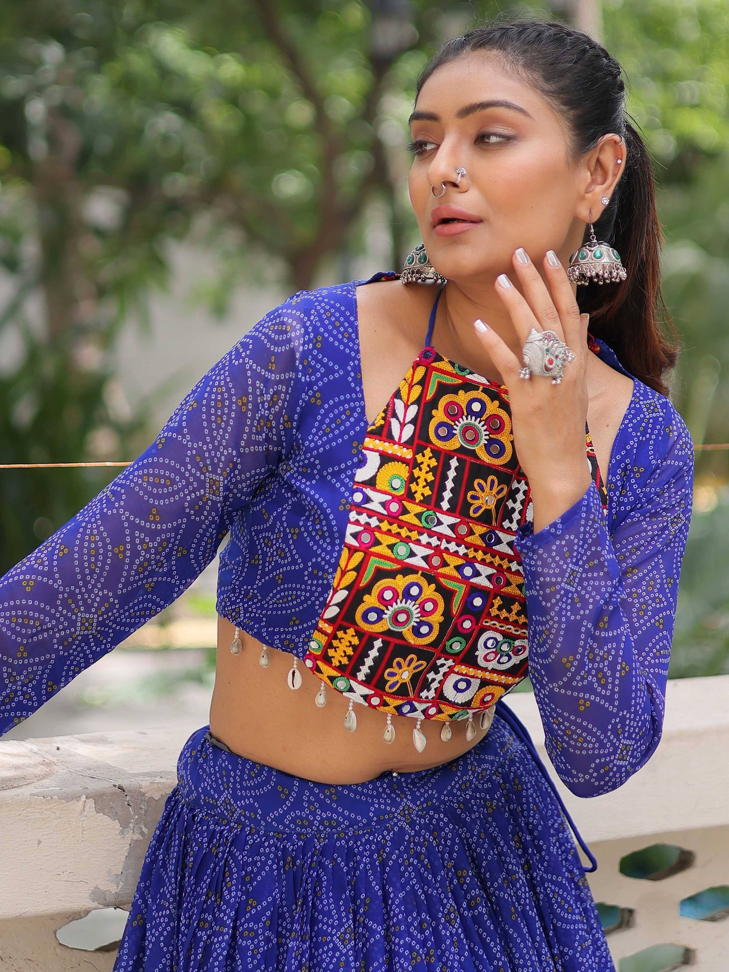 Woman in blue printed ethnic lehenga with colorful mirror work blouse and traditional jewelry