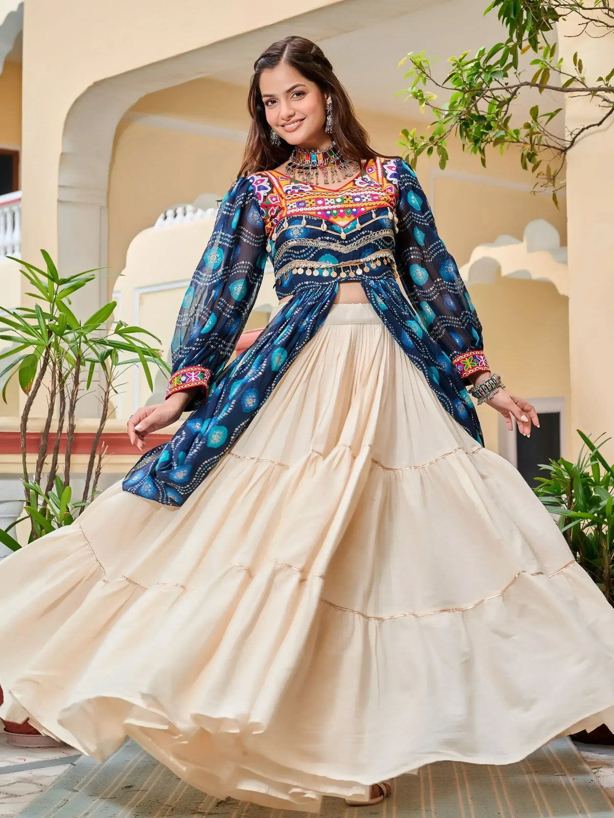 Woman in vibrant blue embroidered crop top with cream tiered skirt, Indian ethnic wear