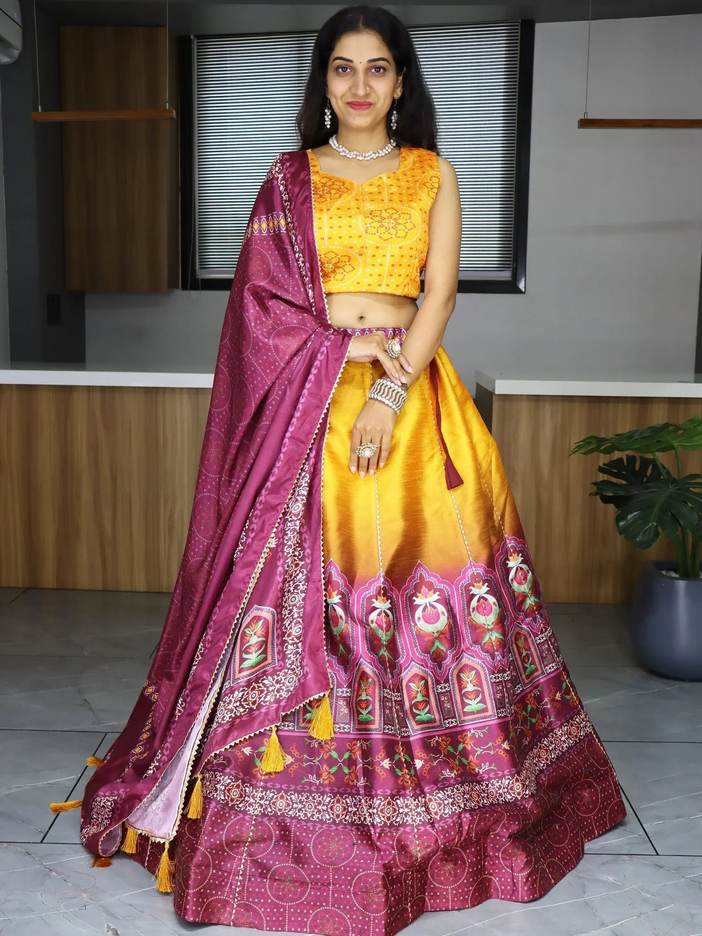 Yellow and maroon designer lehenga choli with floral print and tassels, perfect for Indian ethnic wear occasions
