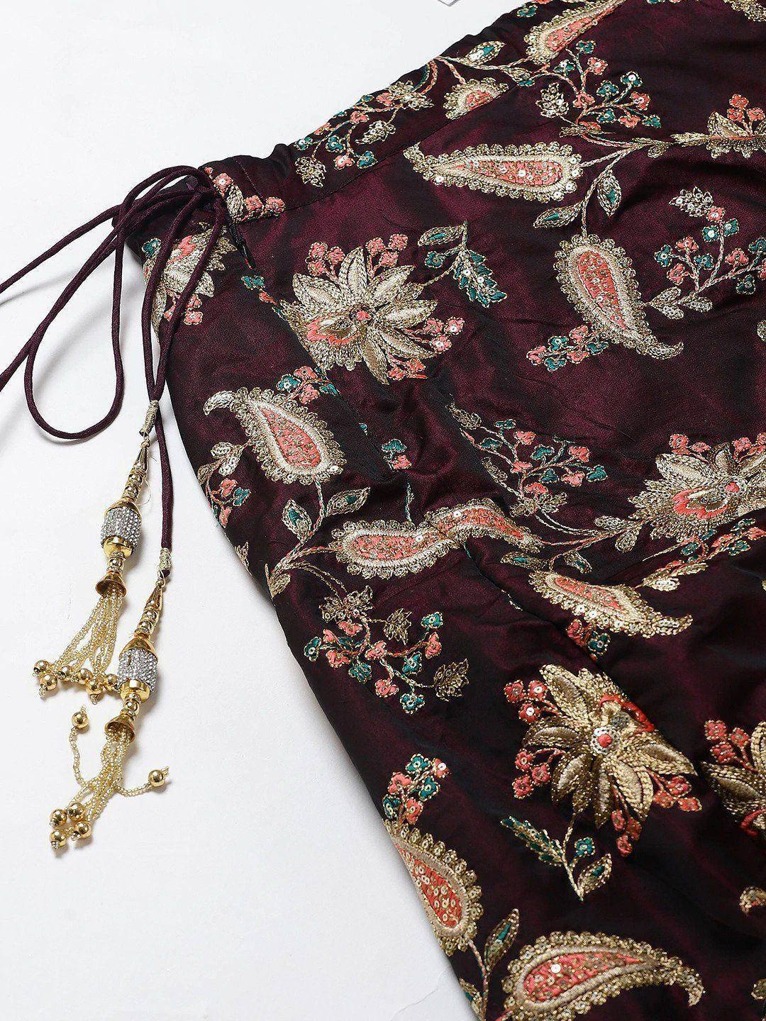 Maroon ethnic gown with floral paisley embroidery and gold tassels, perfect for Indian occasions