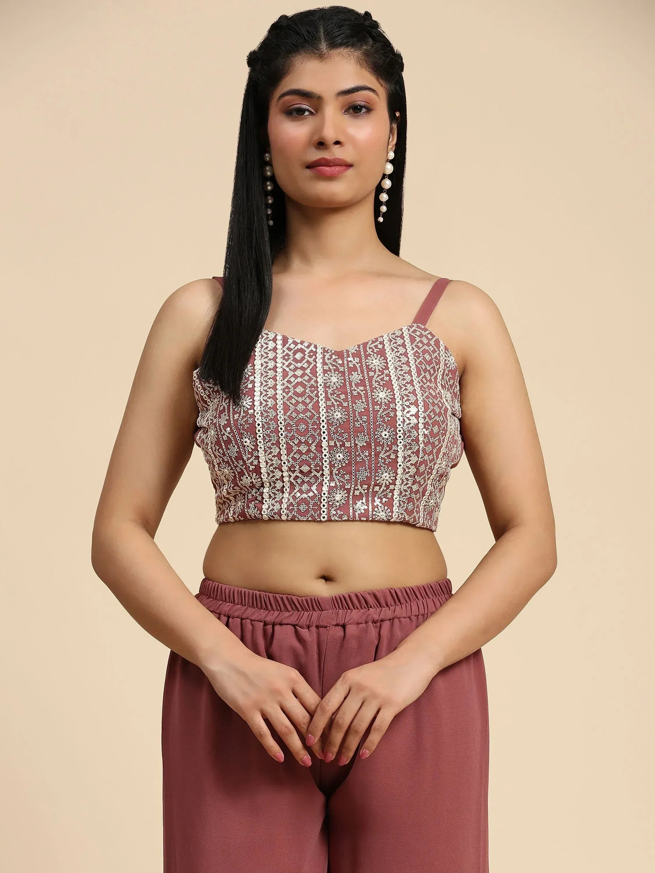 Woman wearing mauve embroidered crop top with thin straps and matching palazzo pants