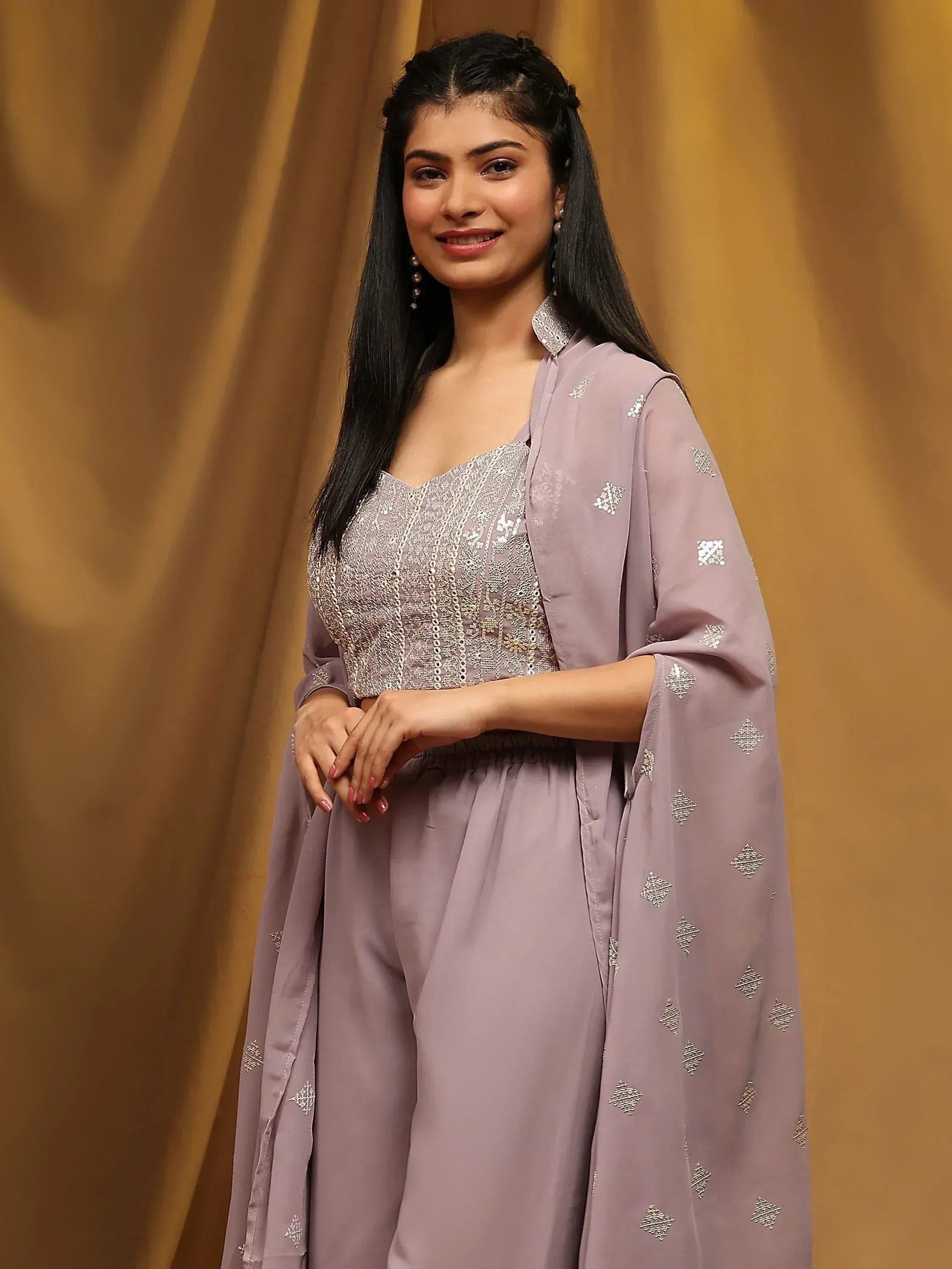 Woman in light lavender ethnic palazzo set with embellished top and dupatta, smiling