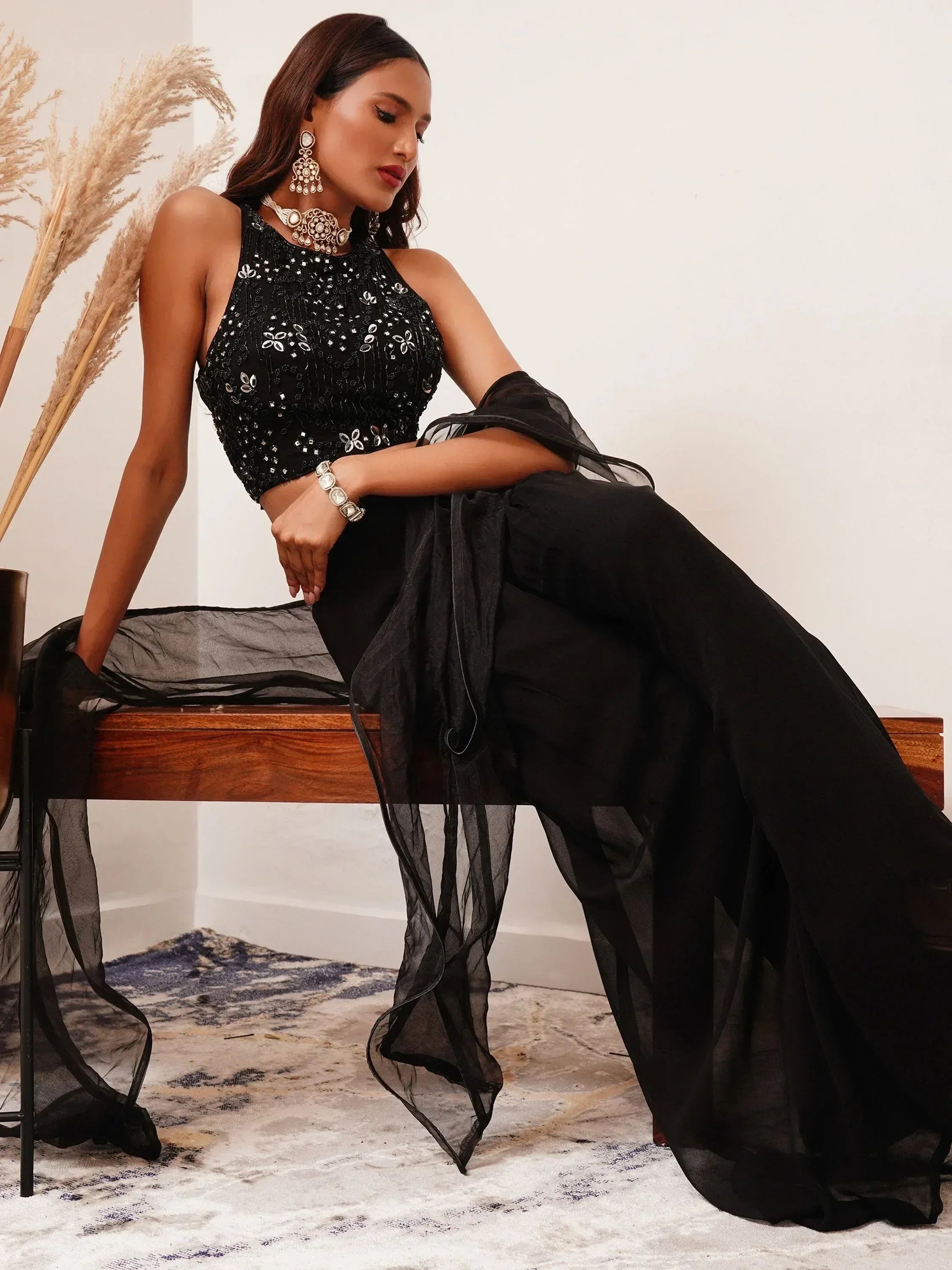 Woman in black embroidered lehenga choli with net dupatta and traditional jewelry