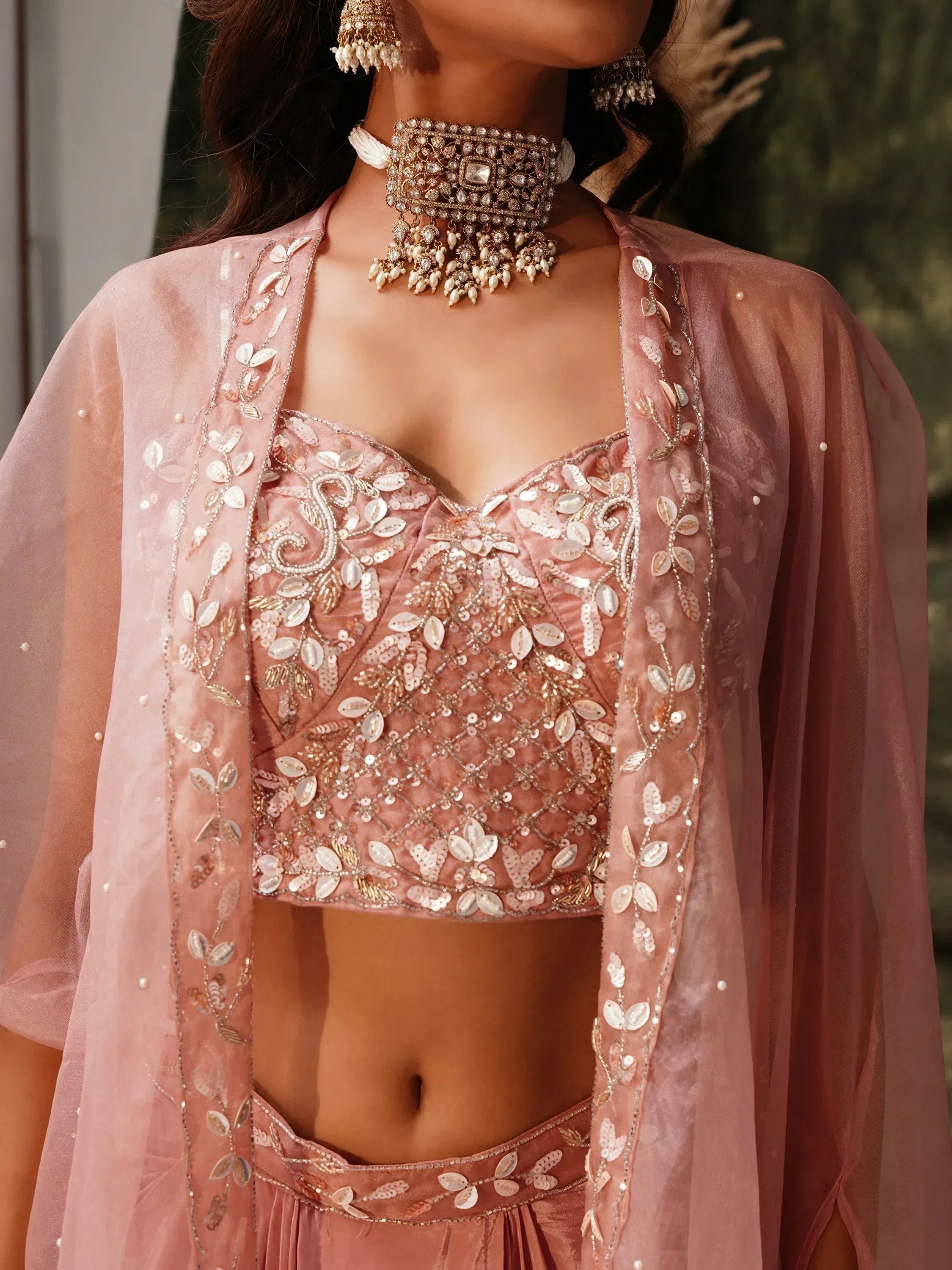 Pink embroidered lehenga choli with sequins, beads, and matching jewelry for Indian ethnic wear