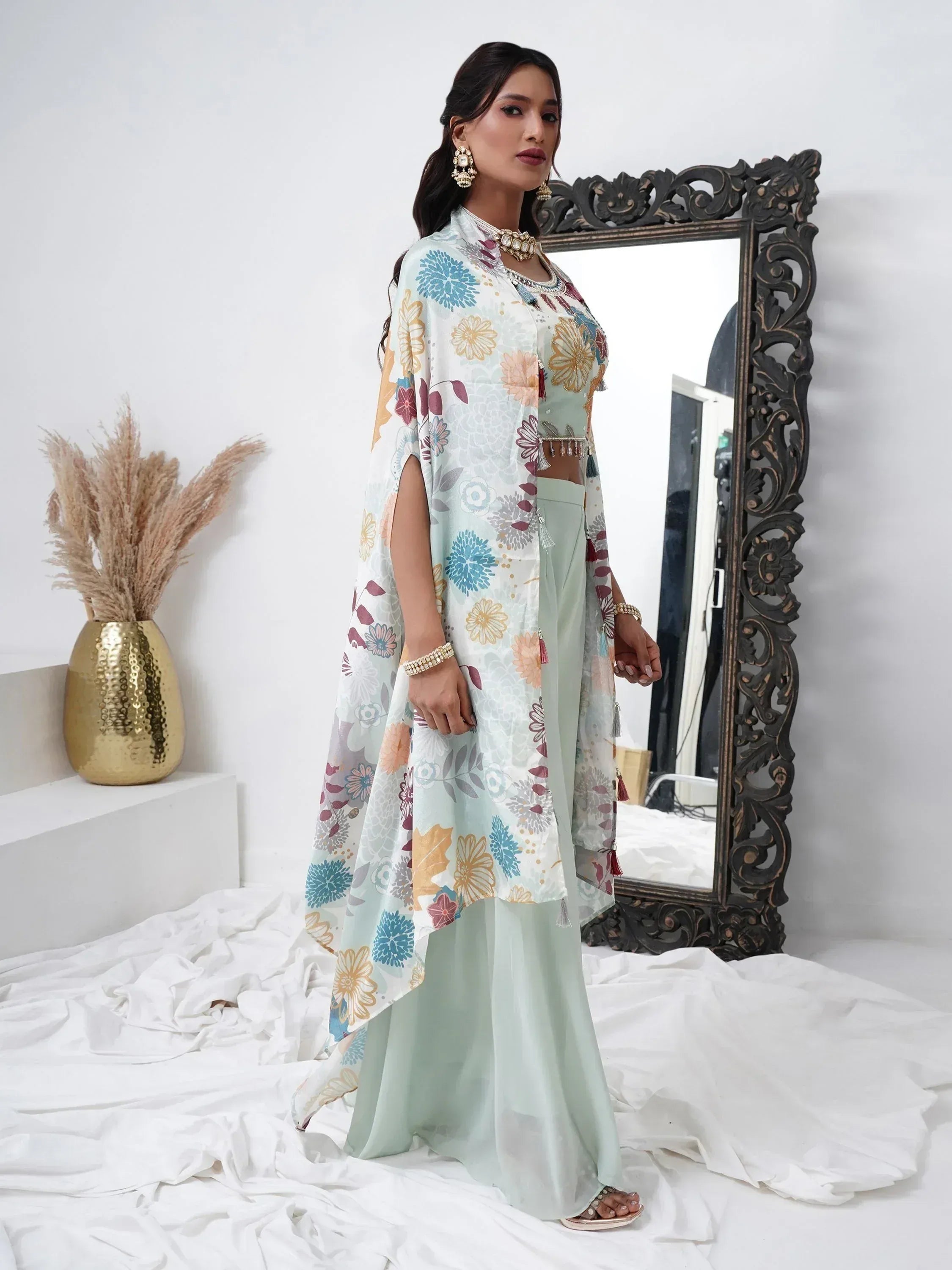 Woman wearing pastel floral ethnic palazzo suit with cape dupatta, standing indoors